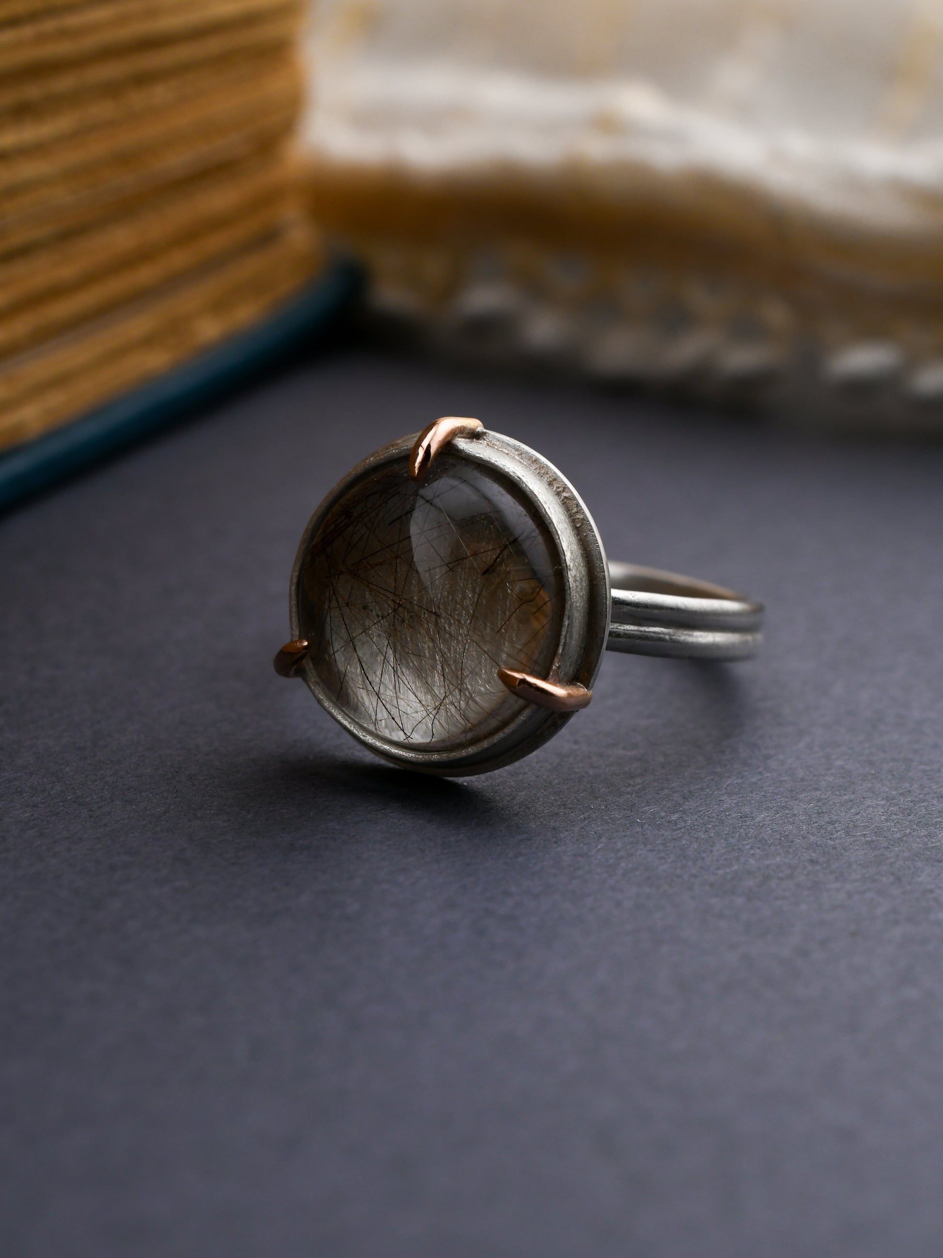 Silver ring with a stone on a dark surface