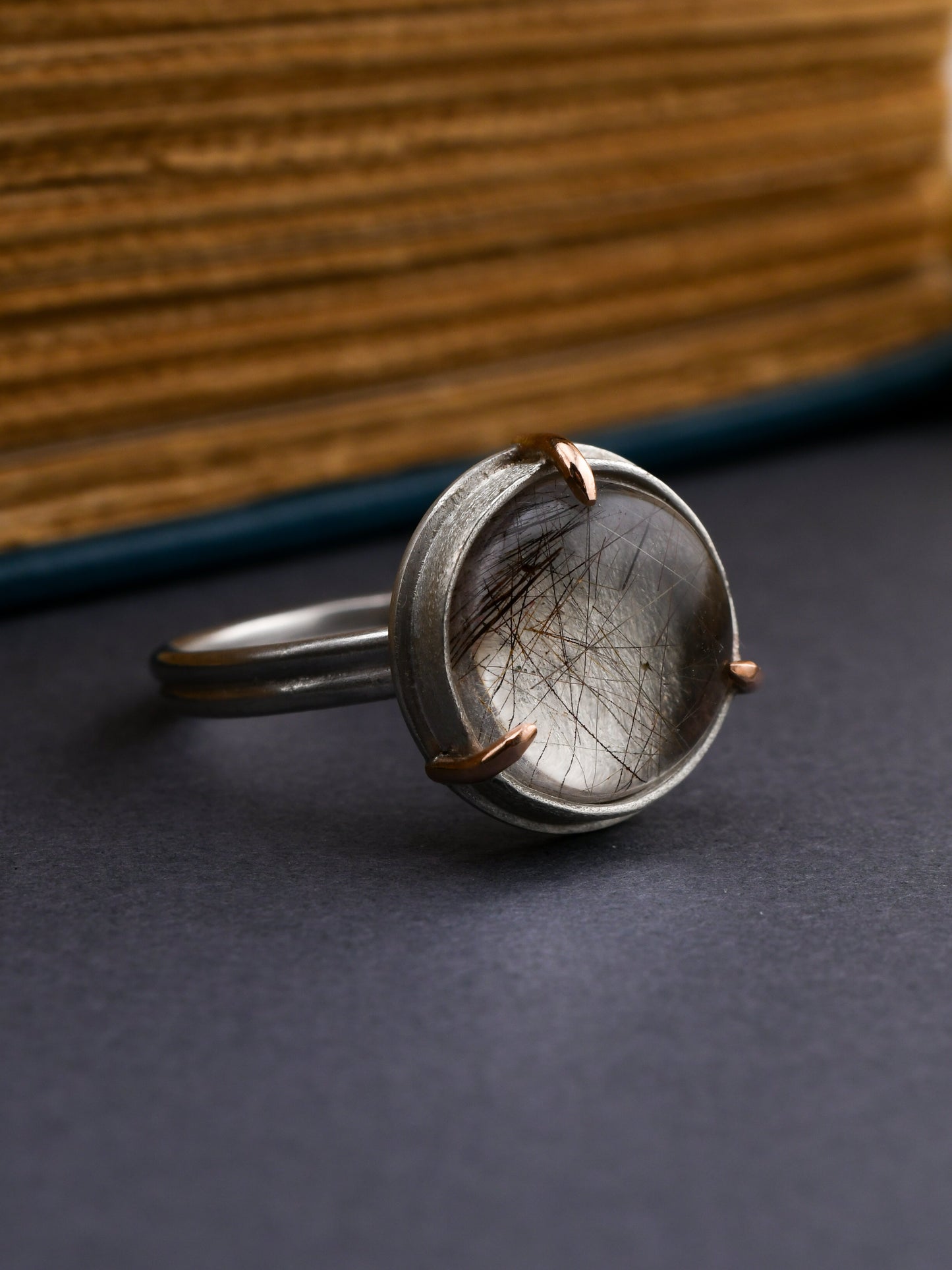 Silver ring with a natural element on a dark surface