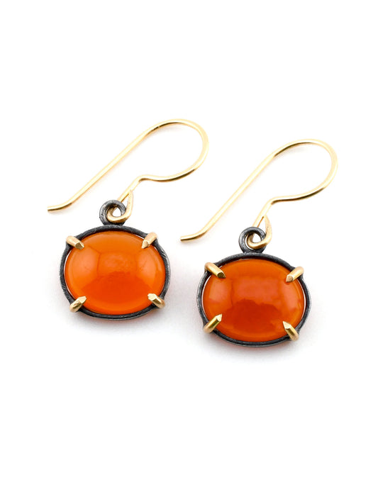 Pair of orange earrings with gold accents on a white background