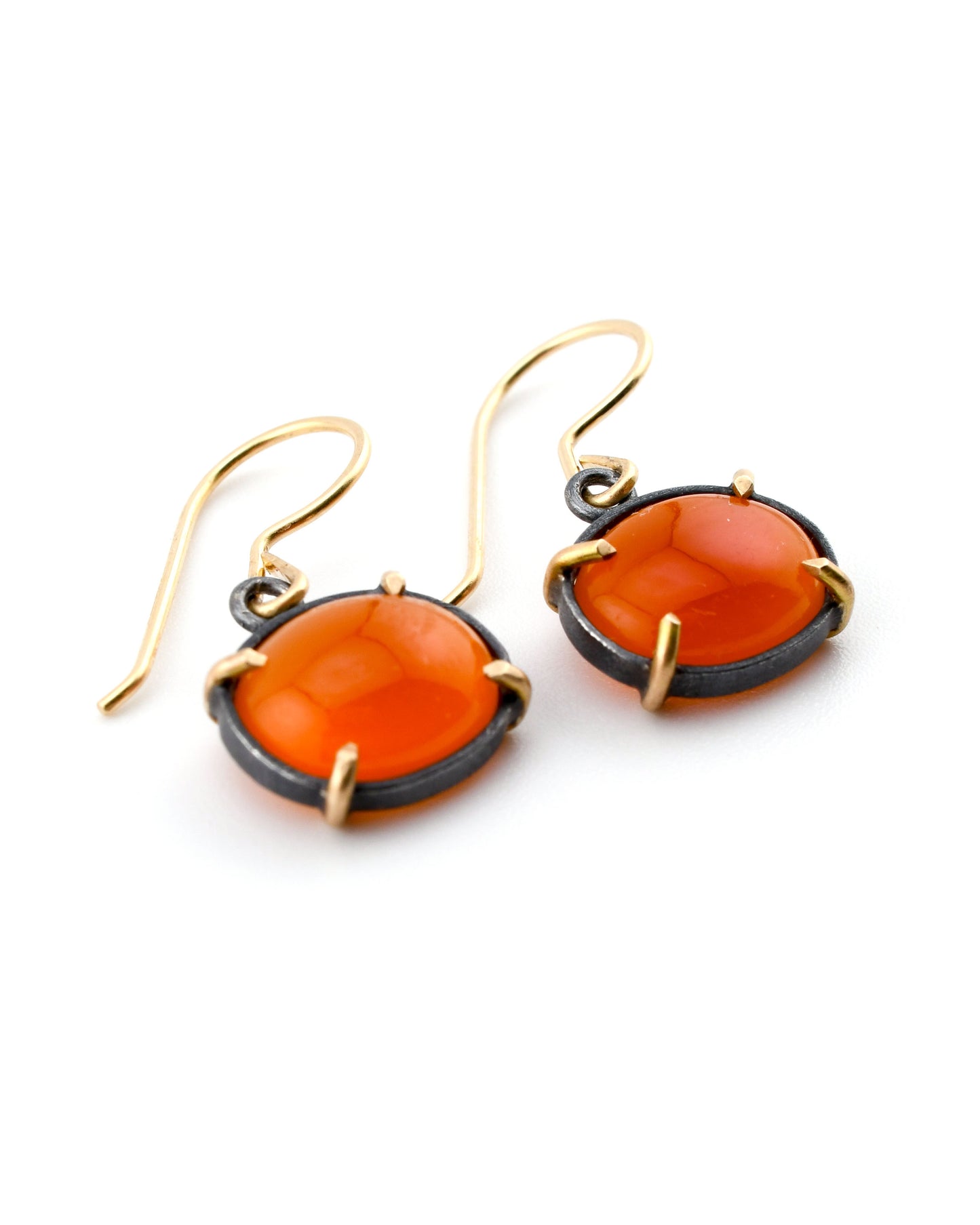 Pair of earrings with orange stones and gold accents on a white background