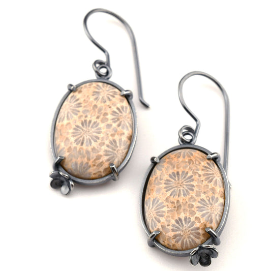 Pair of earrings with floral patterned stones on a white background