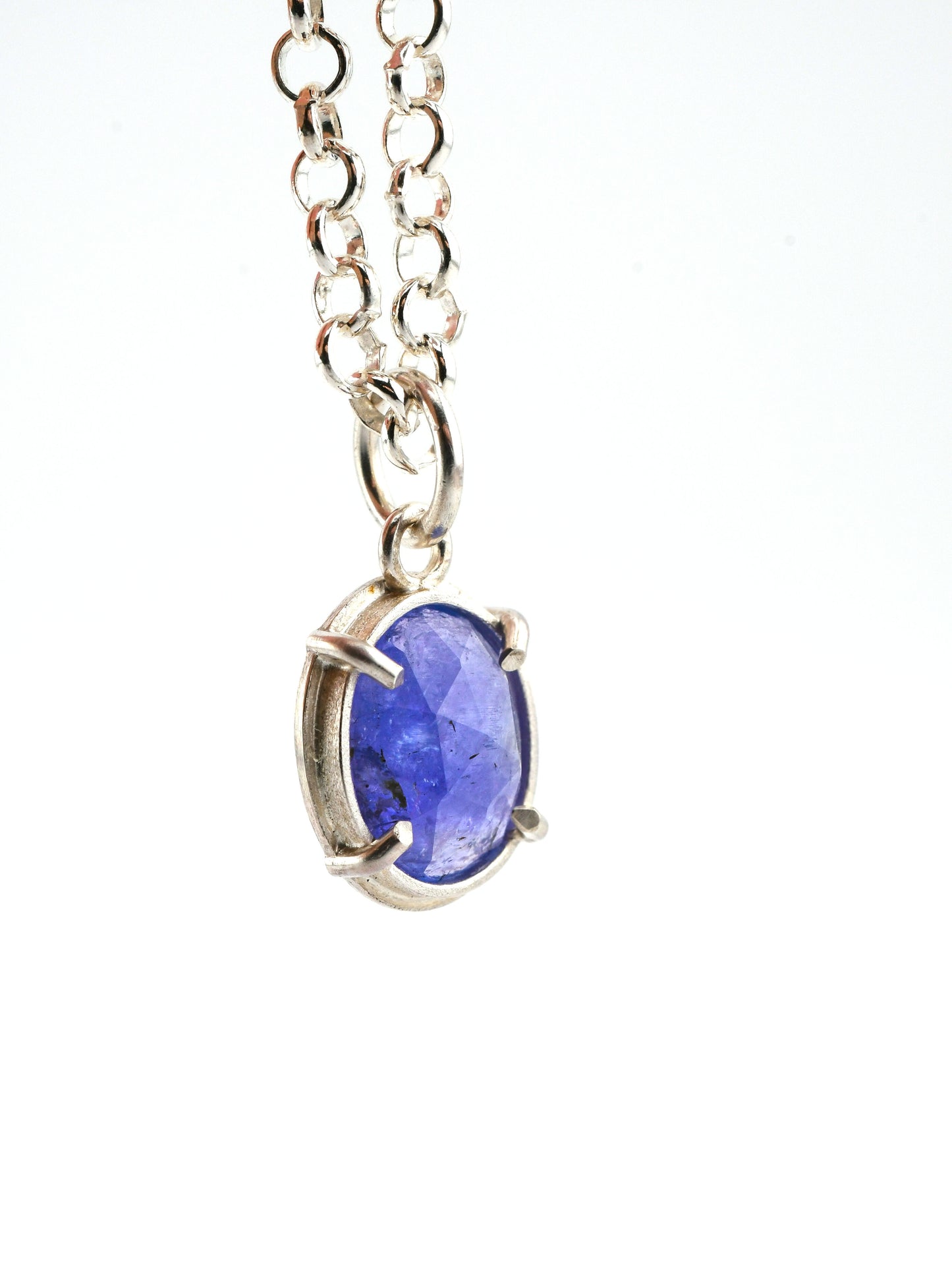 Silver necklace with a blue pendant on a white background