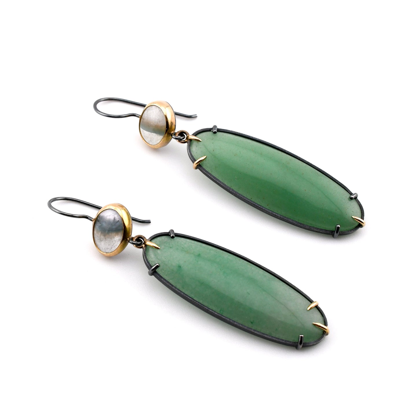 Green earrings with gold accents on a white background