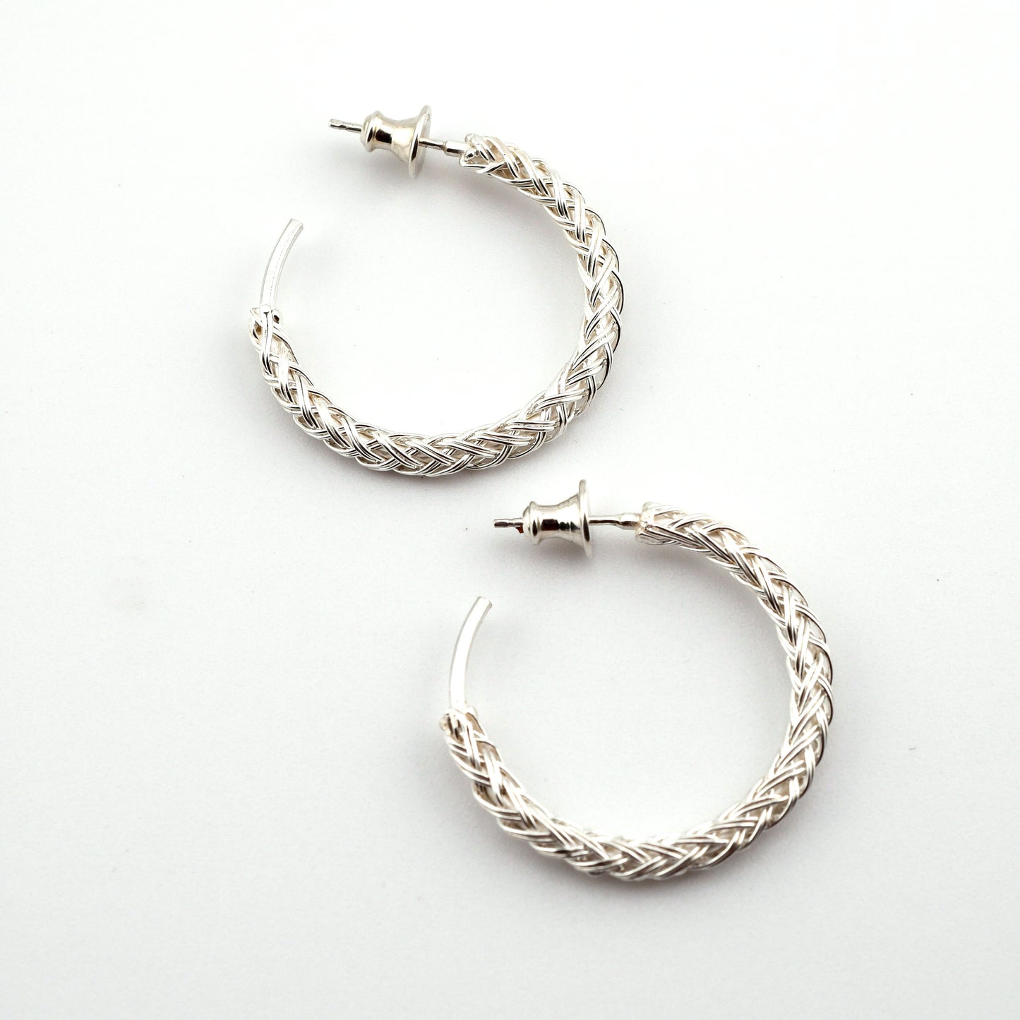 Pair of silver hoop earrings on a white background