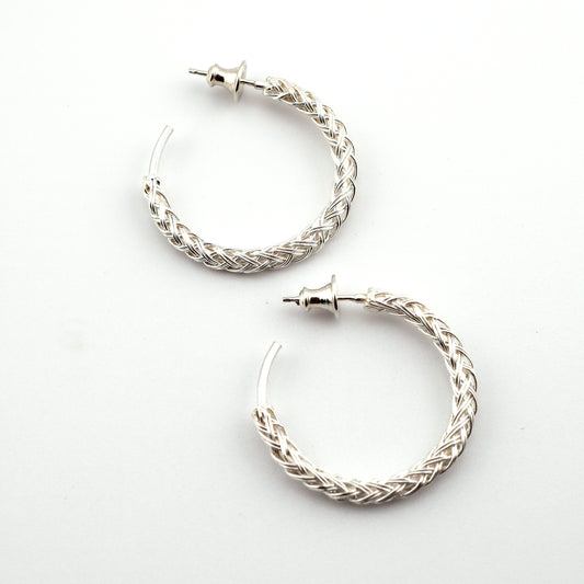 Pair of silver hoop earrings on a white background