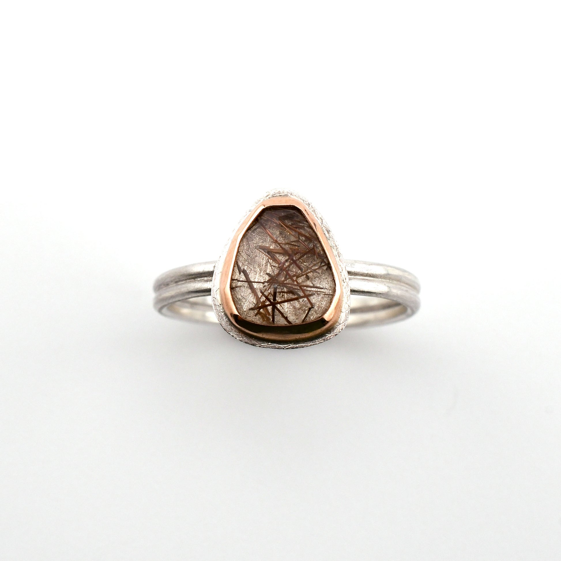 Ring with a teardrop-shaped gemstone on a white background