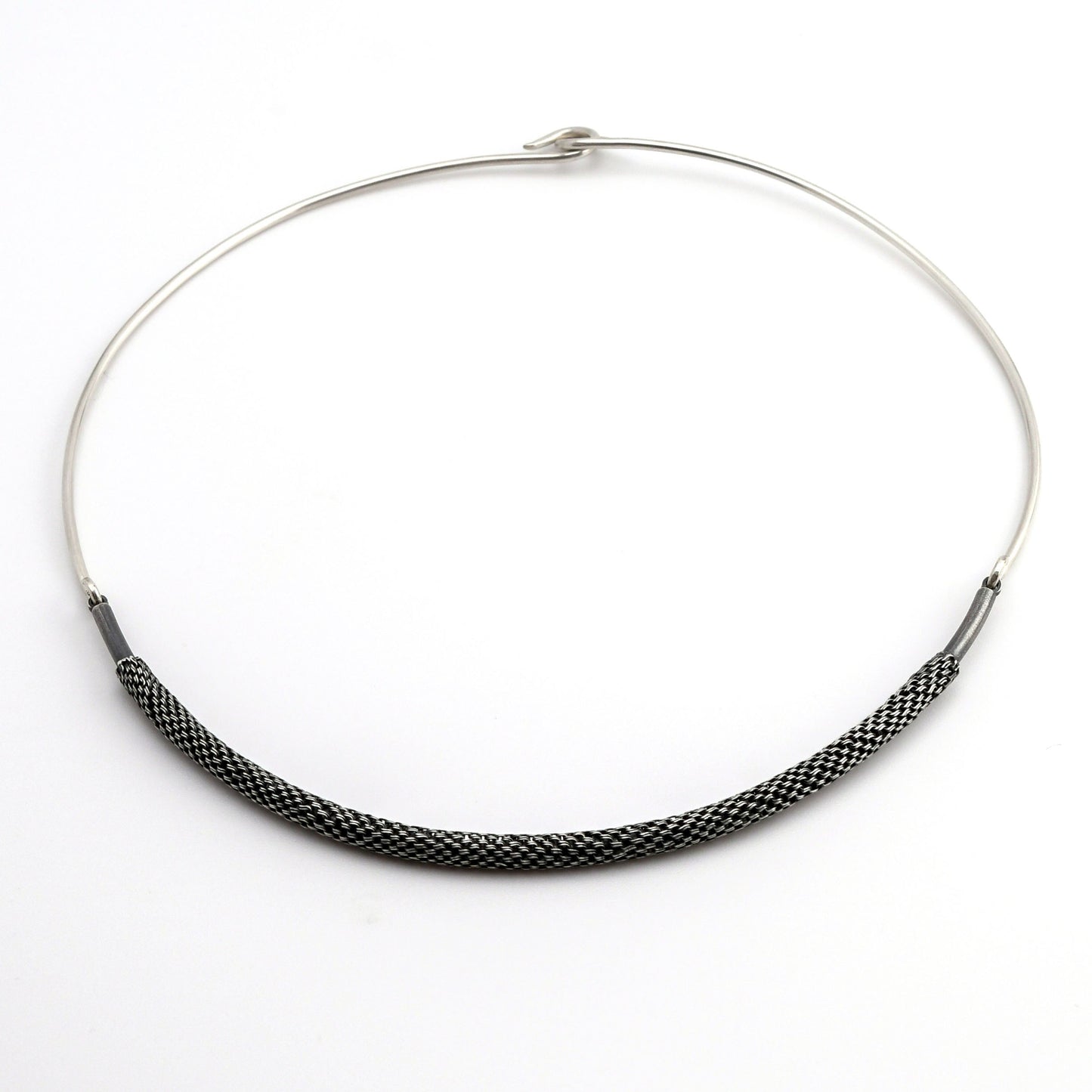 Silver torque necklace with woven silver front piece on a white background