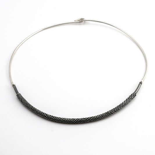Silver torque necklace with woven silver front piece on a white background