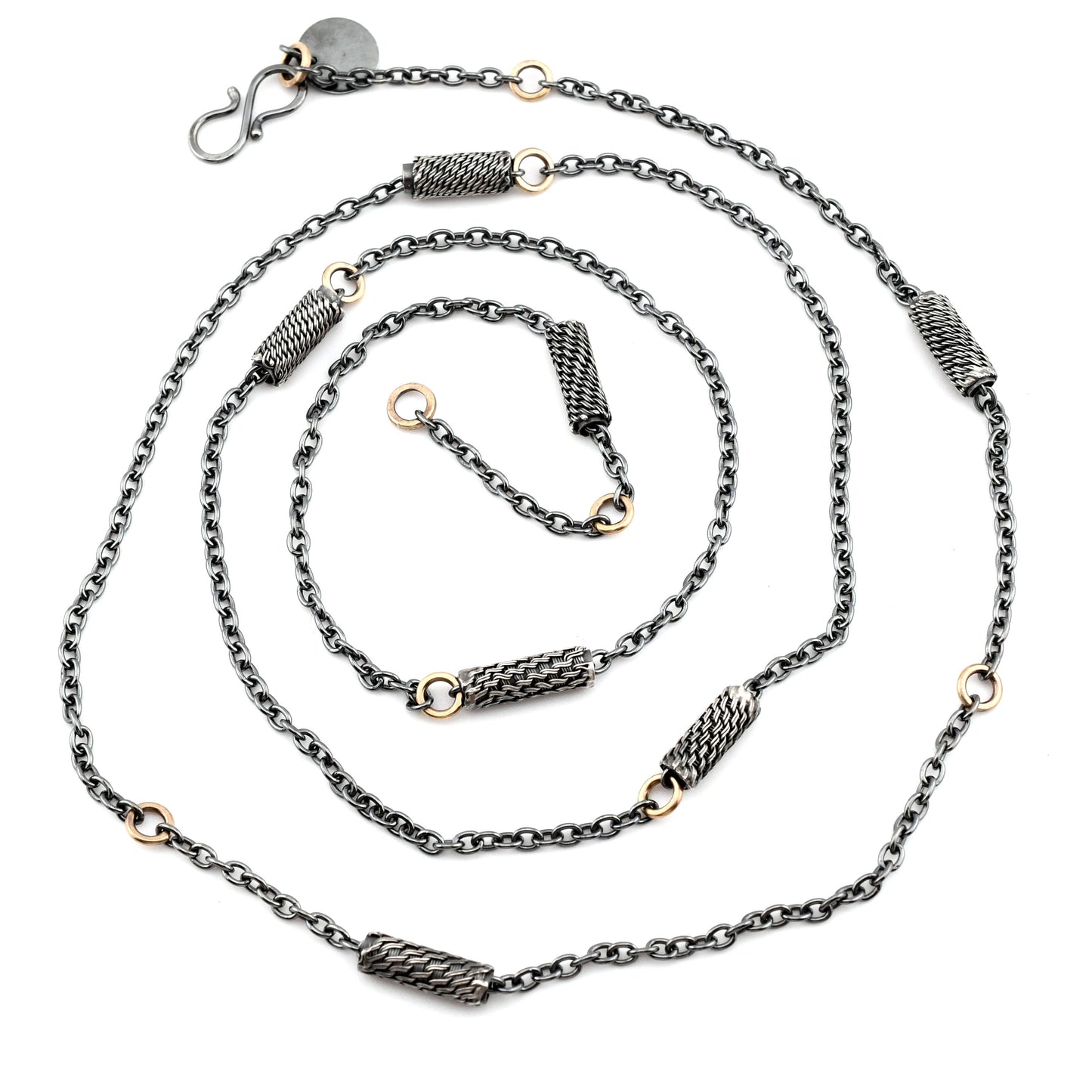 Black silver chain necklace with woven silver beads and 14k gold links arranged in a spiral on a white background