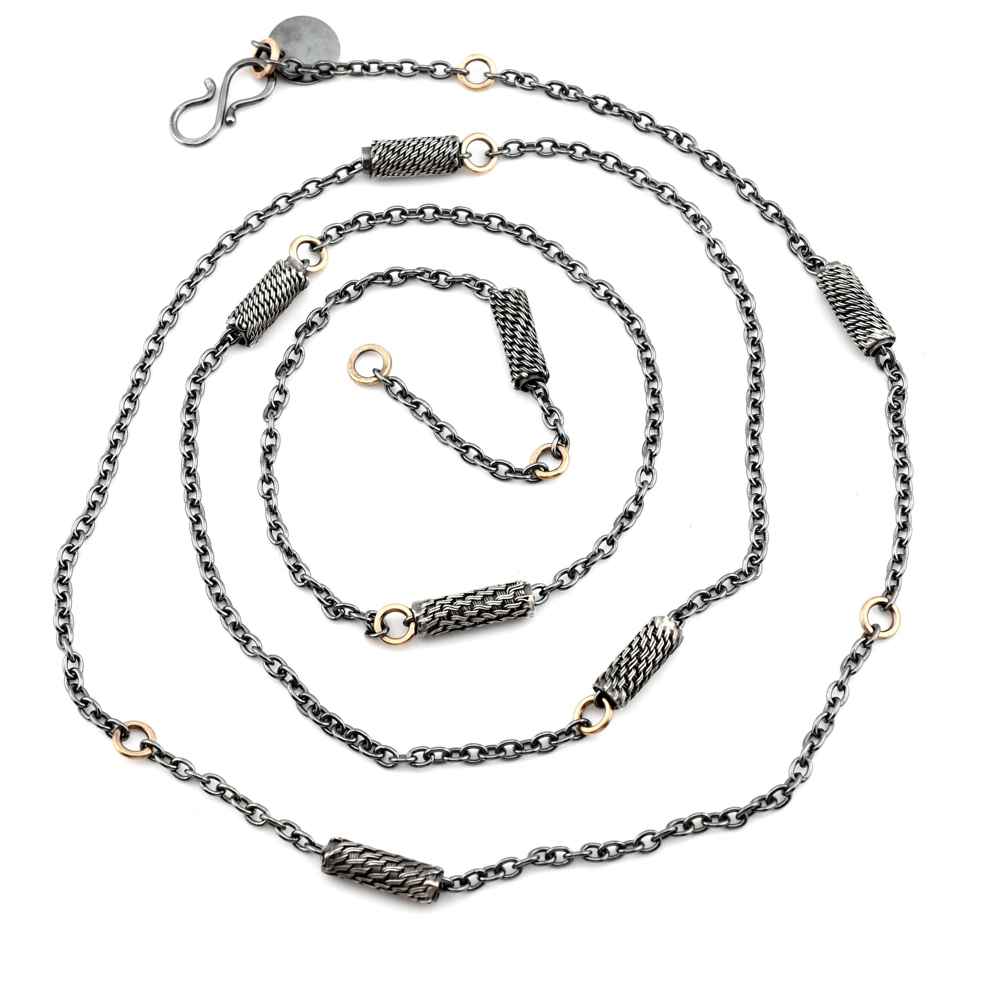Black silver chain necklace with woven silver beads and 14k gold links arranged in a spiral on a white background