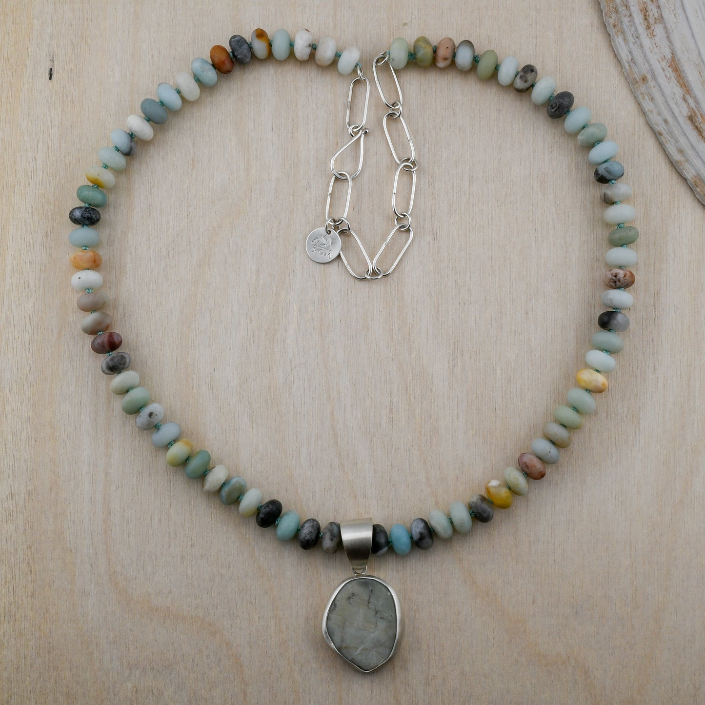 Necklace with multicolored beads and a pendant on a wooden surface