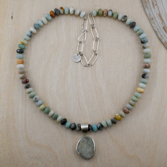 Necklace with multicolored beads and a pendant on a wooden surface