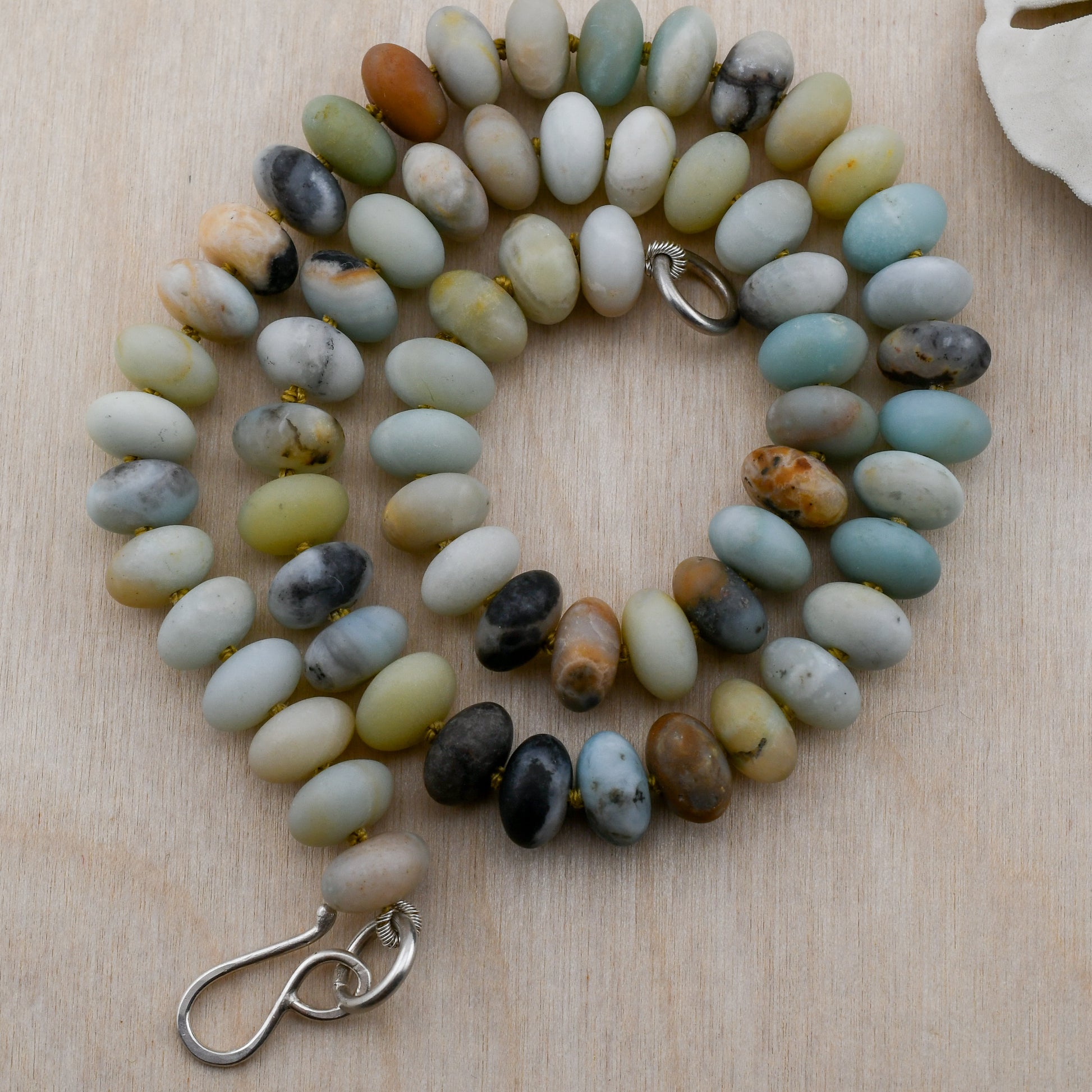 Beaded necklace with natural stone beads on a wooden surface