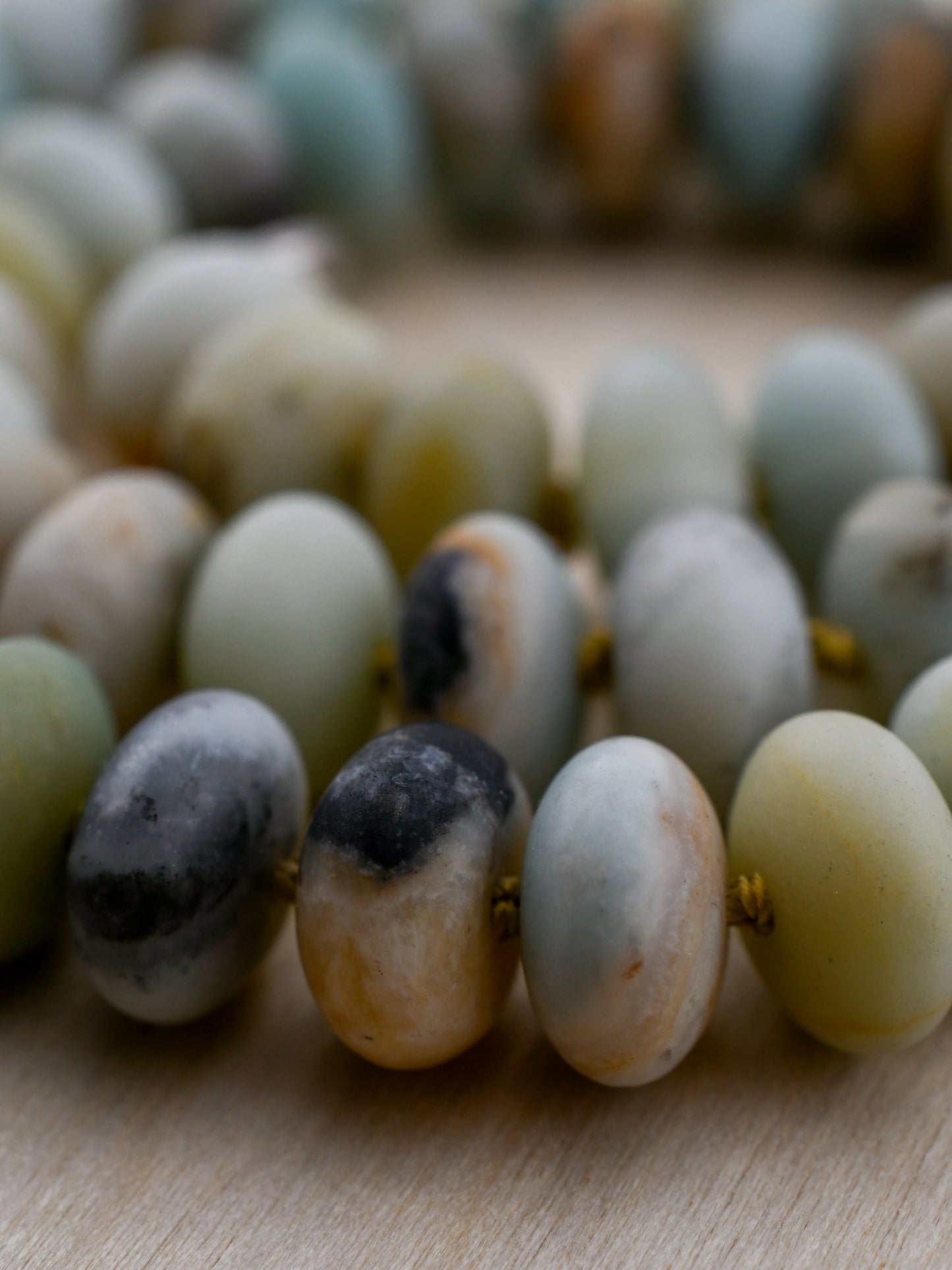 Close-up of a beaded necklace with natural stone beads on a wooden surface