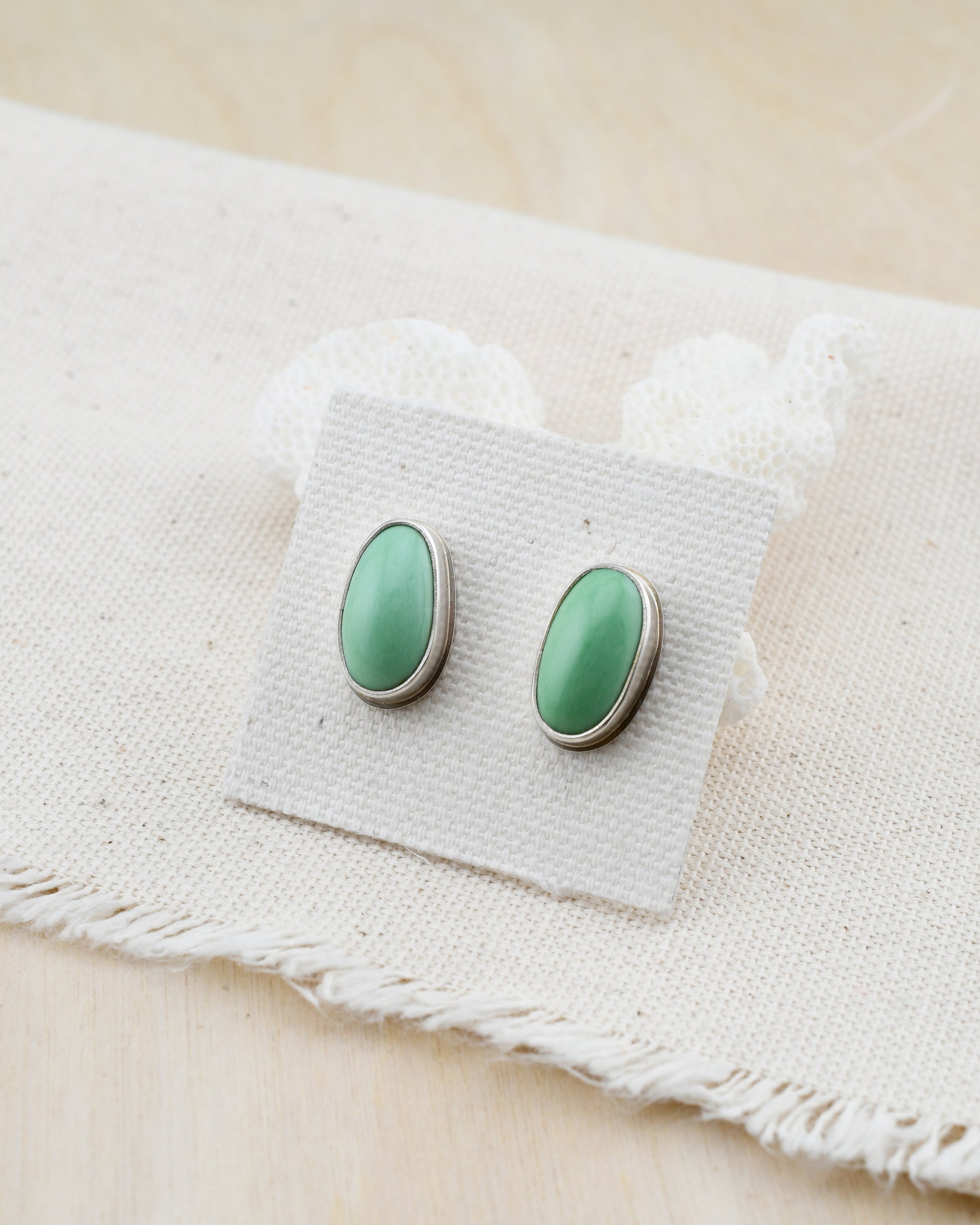 silver and green variscite stud earrings on natural linen and white coral