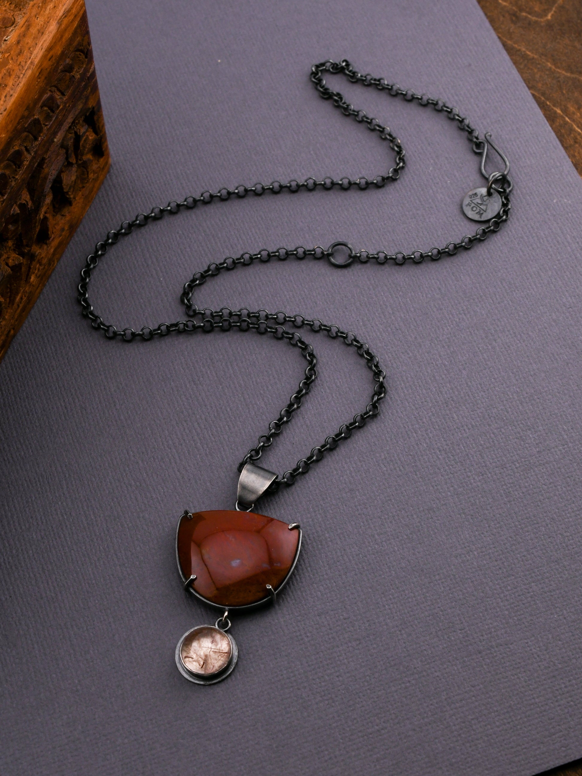 Necklace with a red pendant on a dark surface