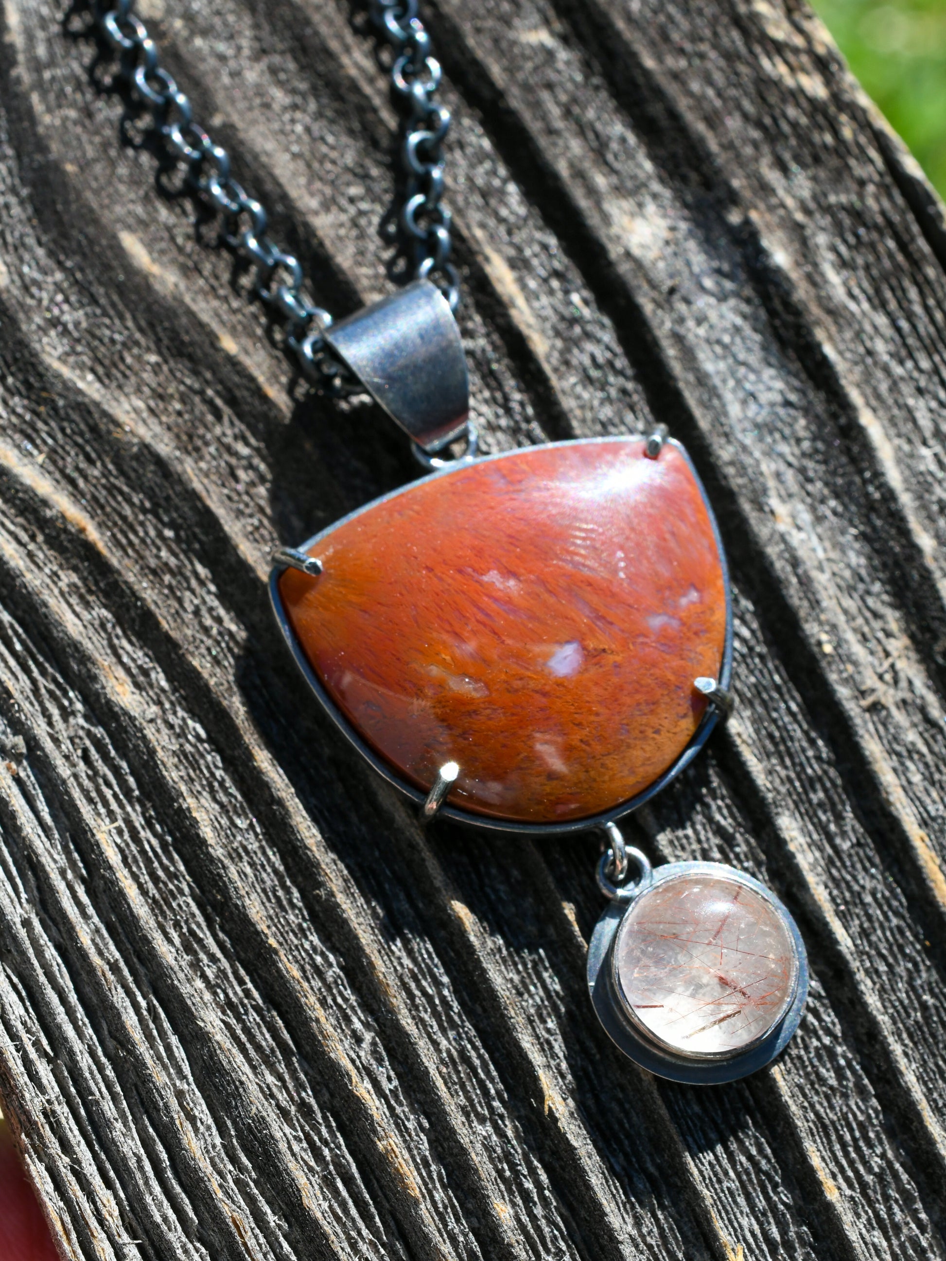 Necklace with a large red stone pendant on a wooden surface