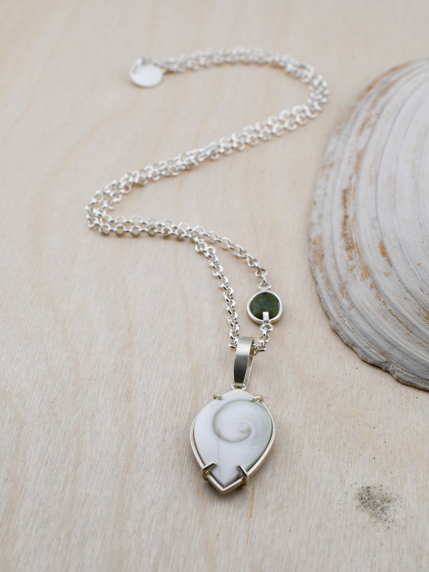 Necklace with a white shell pendant on a wooden surface