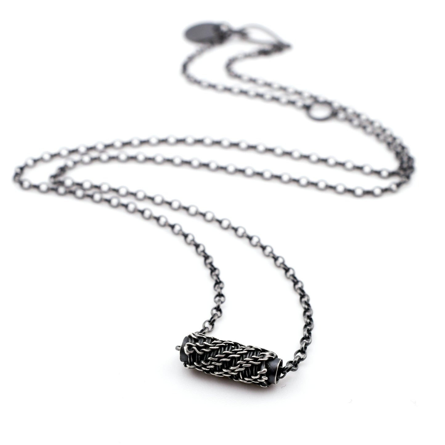 Silver necklace with a woven sliding bead pendant on a white background