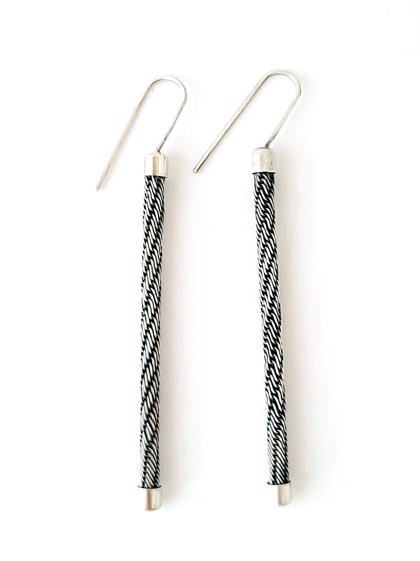 Pair of earrings with black and white striped design on a white background