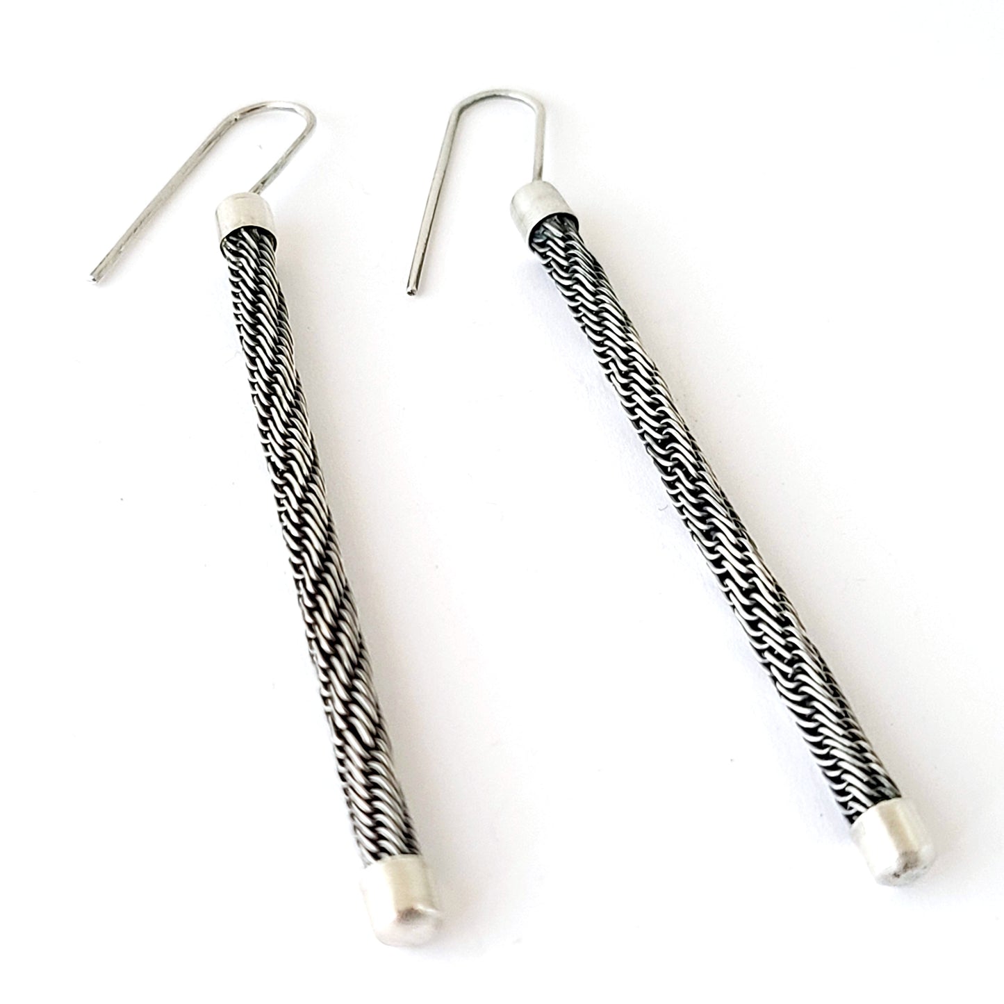 Pair of black and white patterned earrings on a white background