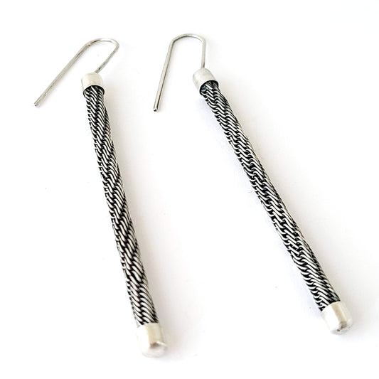 Pair of black and white patterned earrings on a white background