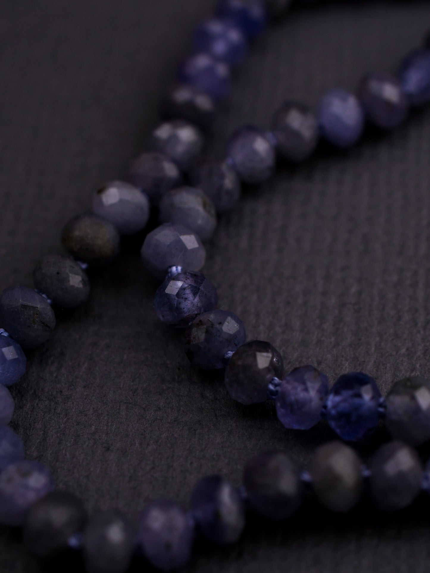 Close-up of a necklace with blue beads on a dark background