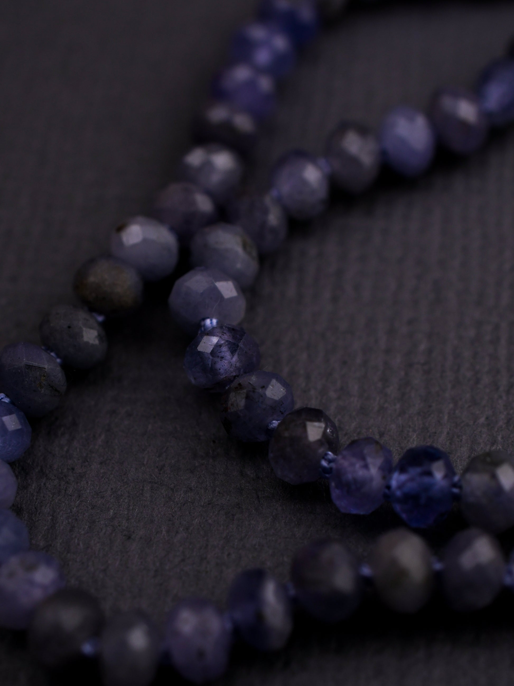 Close-up of a necklace with blue beads on a dark background