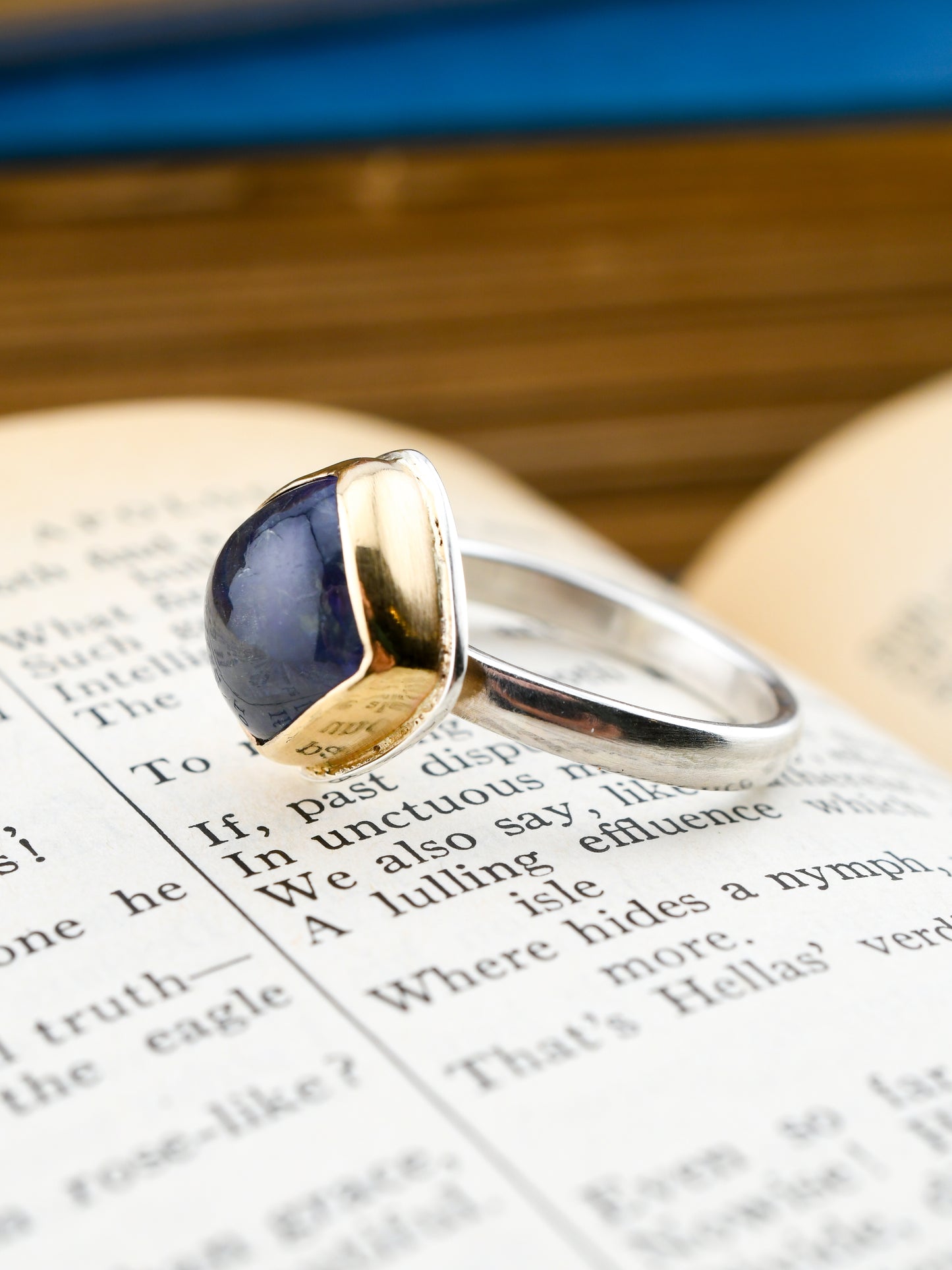 Gold and silver ring with a blue stone on an open book