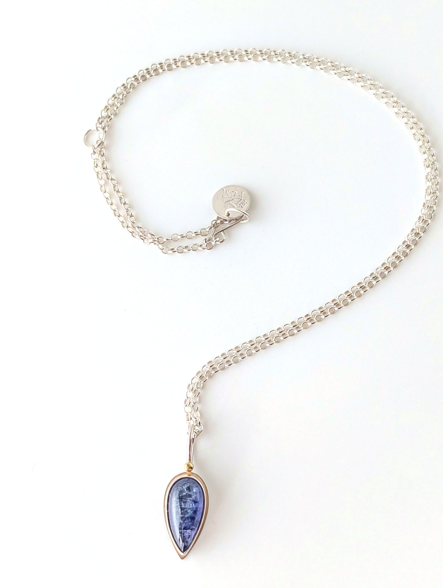 Silver necklace with a blue pendant on a white background