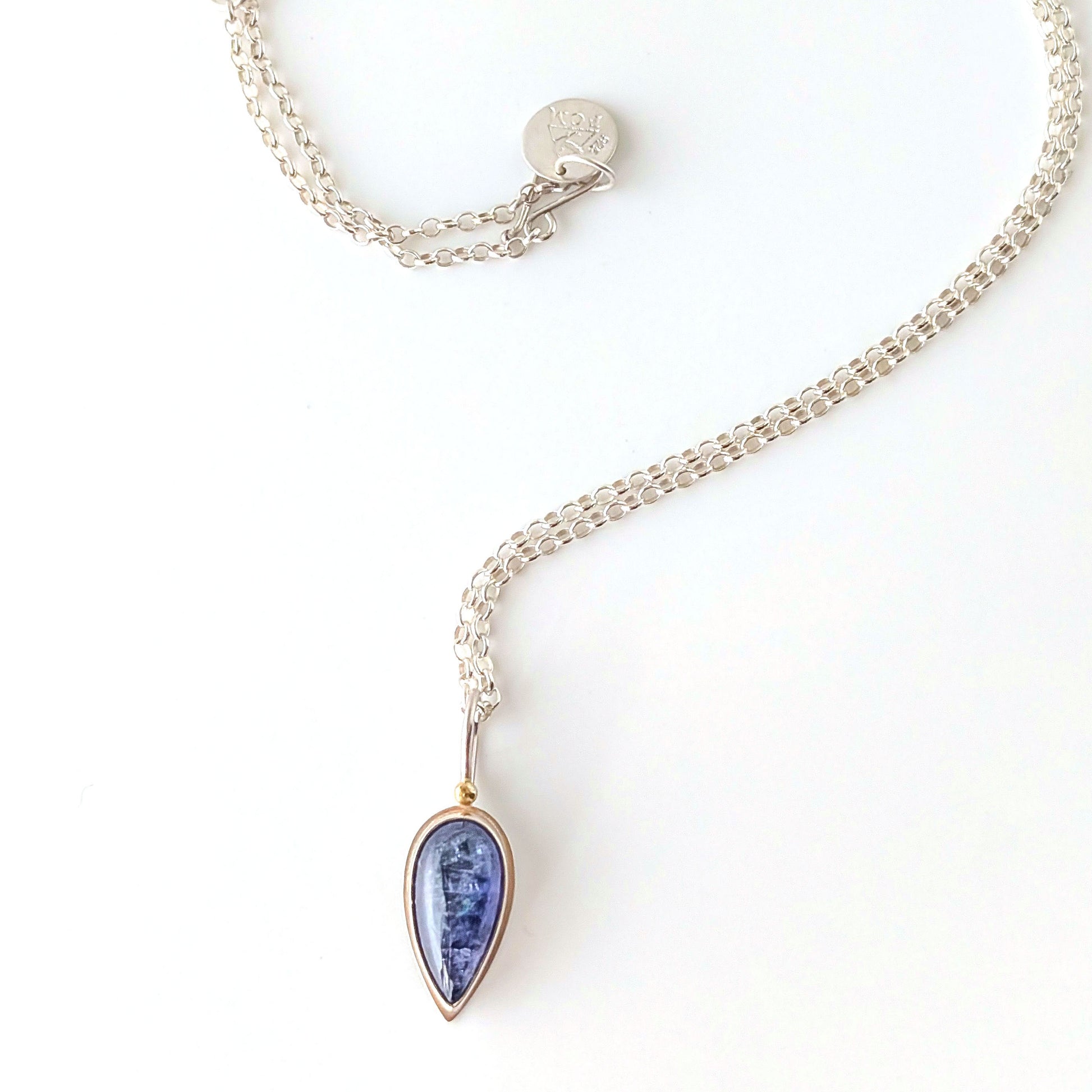 violet gemstone necklace with a silver chain on a white background