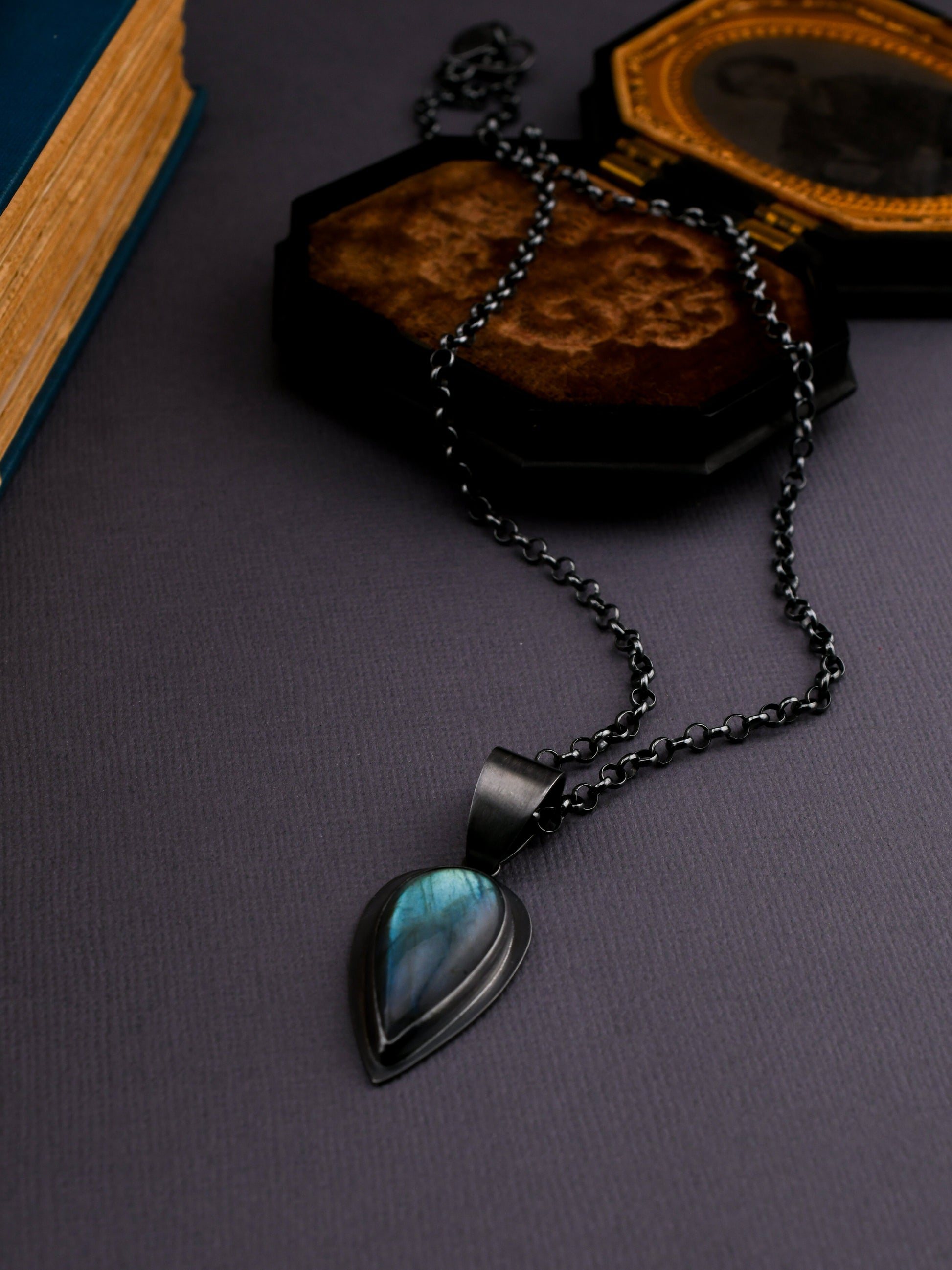 Necklace with a teardrop-shaped pendant on a dark surface
