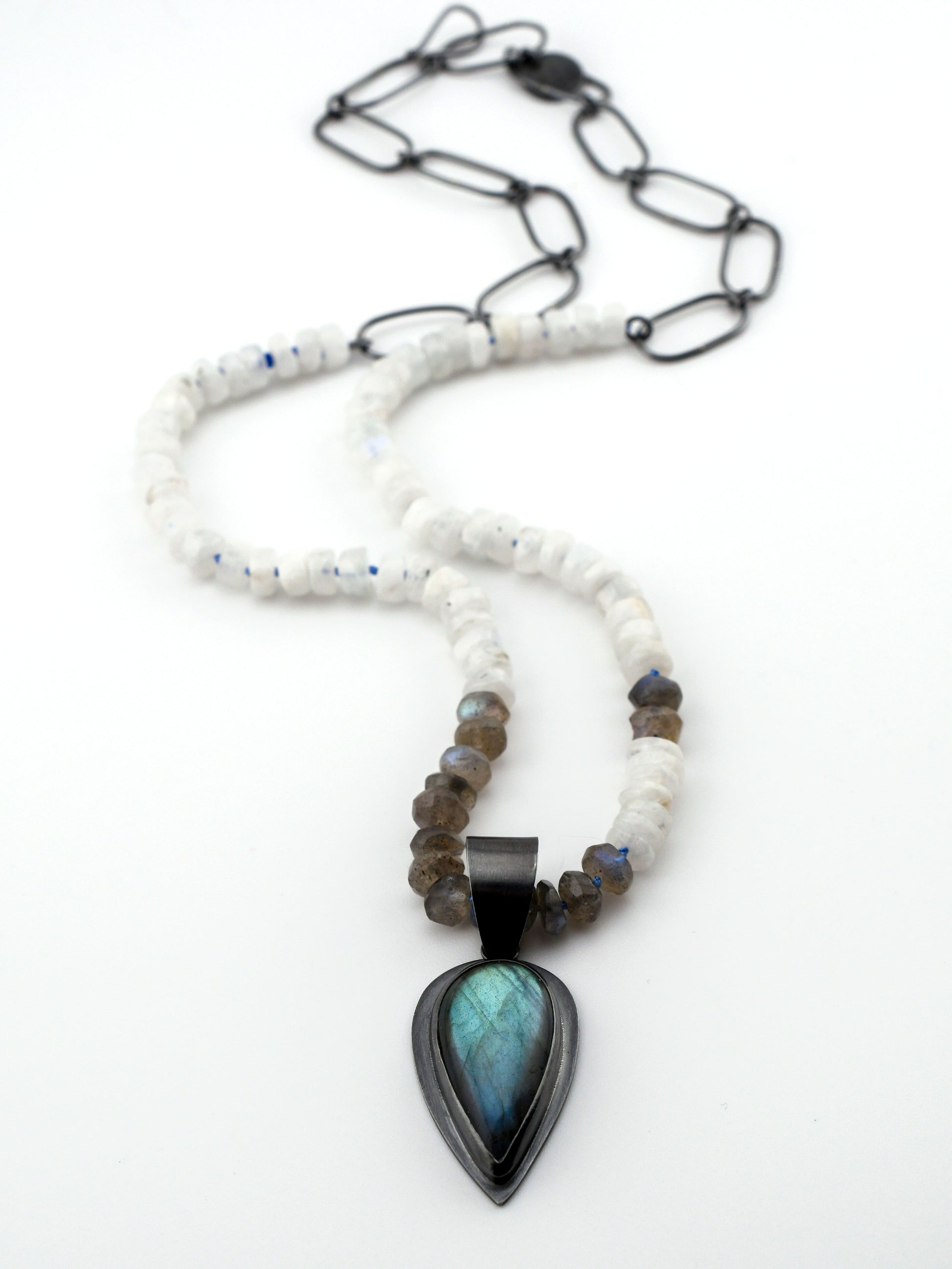 Necklace with a pendant featuring a blue stone on a white background
