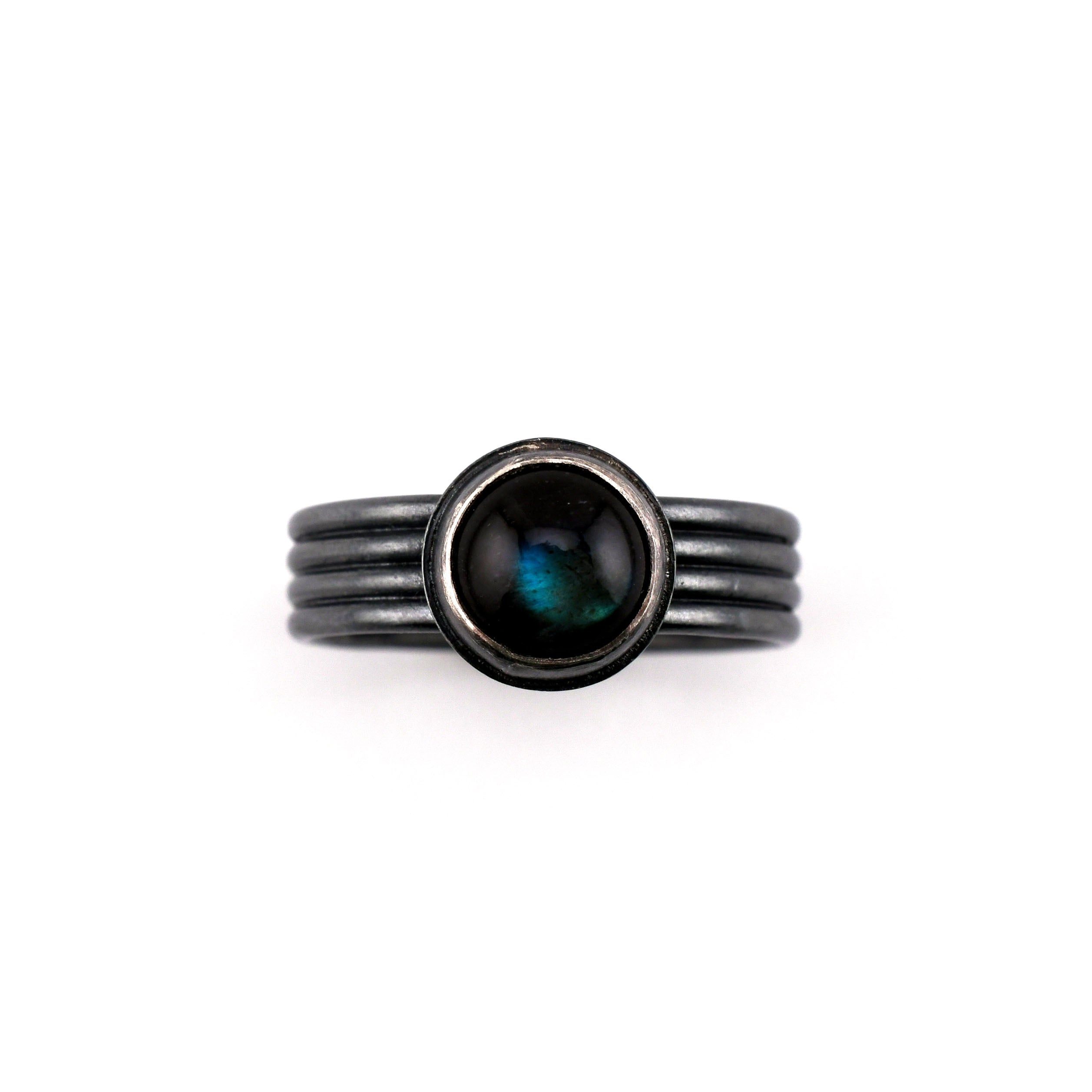 Black ring with a central gemstone on a white background