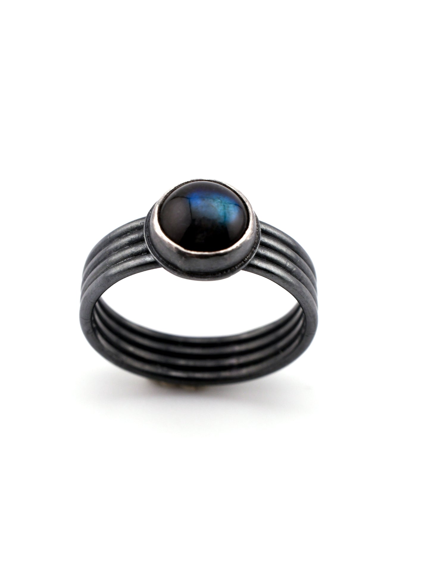 Black ring with a central gemstone on a white background