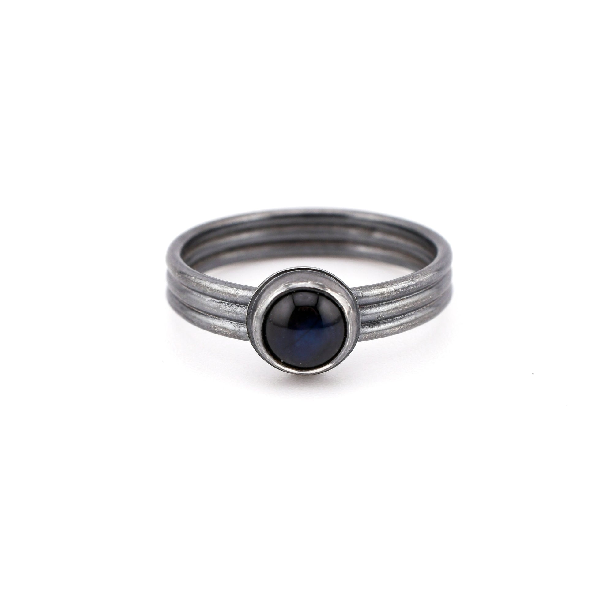 Silver ring with blue gemstone on a white background
