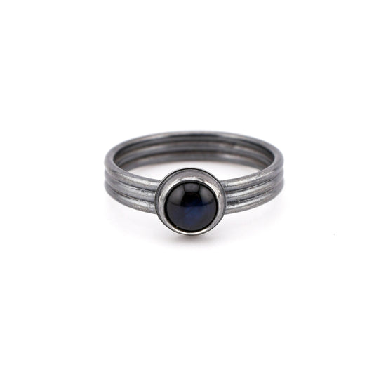 Silver ring with blue gemstone on a white background