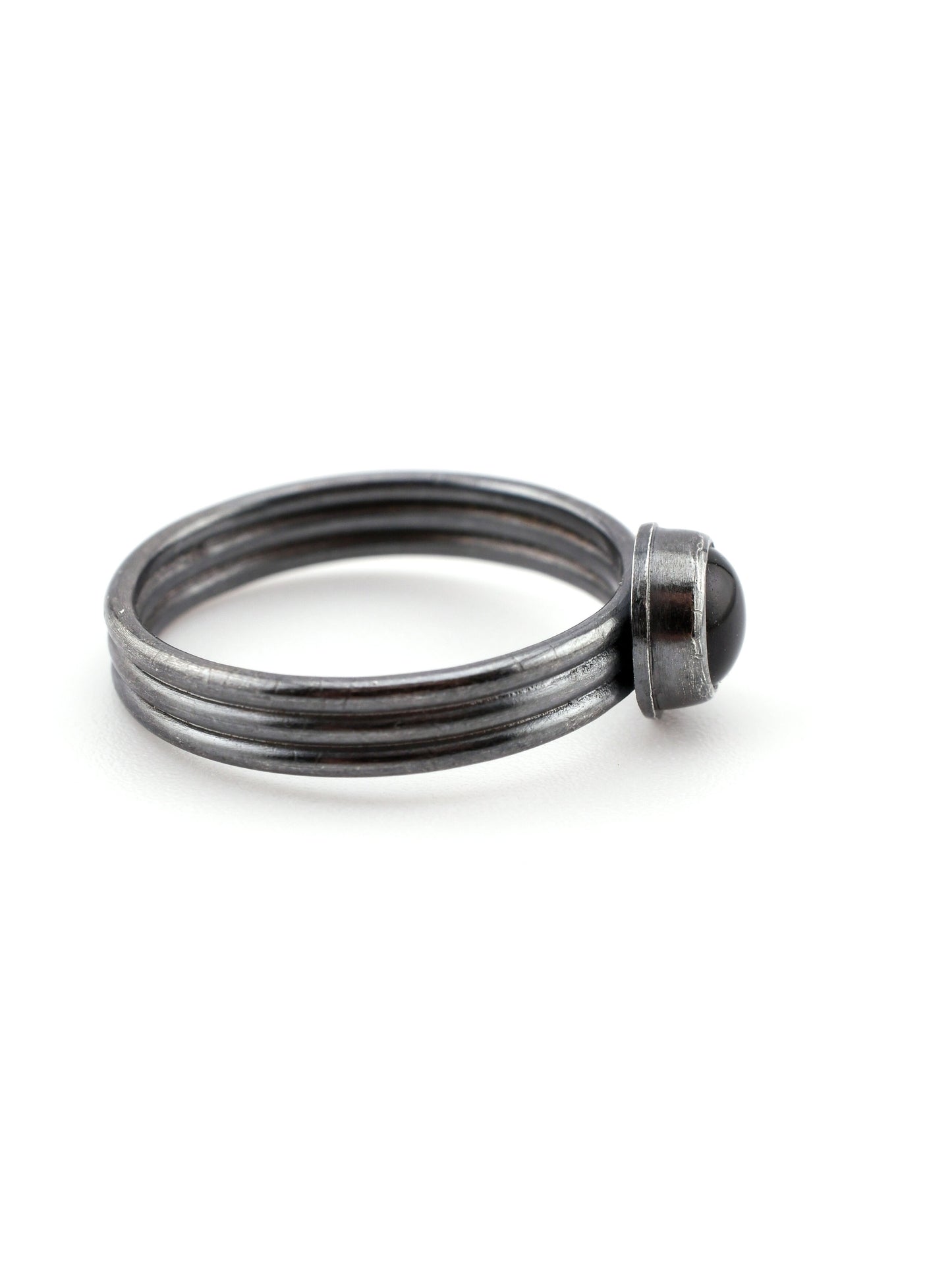 Silver ring with a dark blue stone on a white background