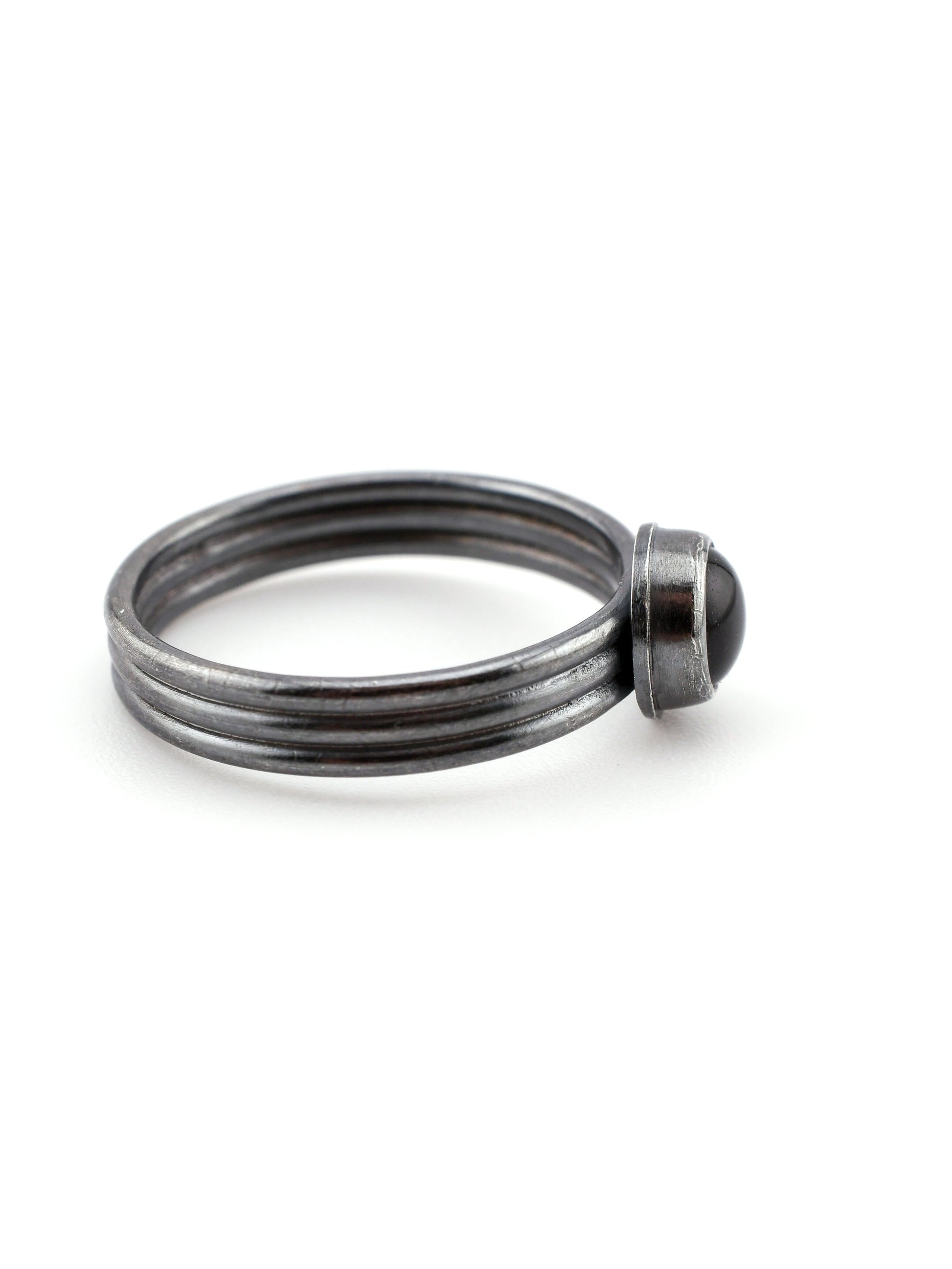 Silver ring with a dark blue stone on a white background