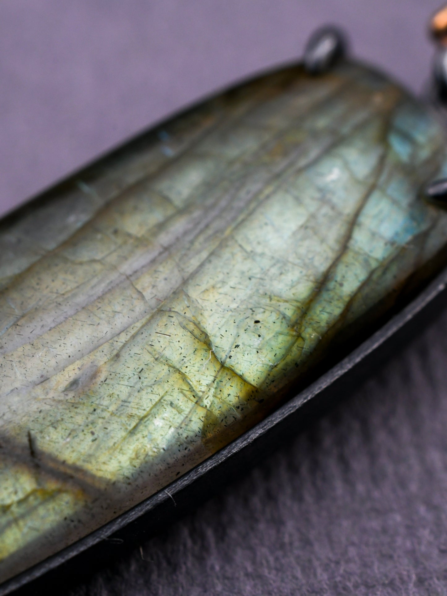 Close-up of a labradorite stone with a dark gray background