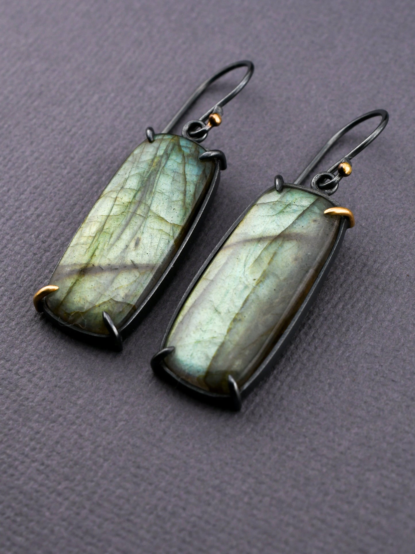 Pair of green stone earrings on a gray background