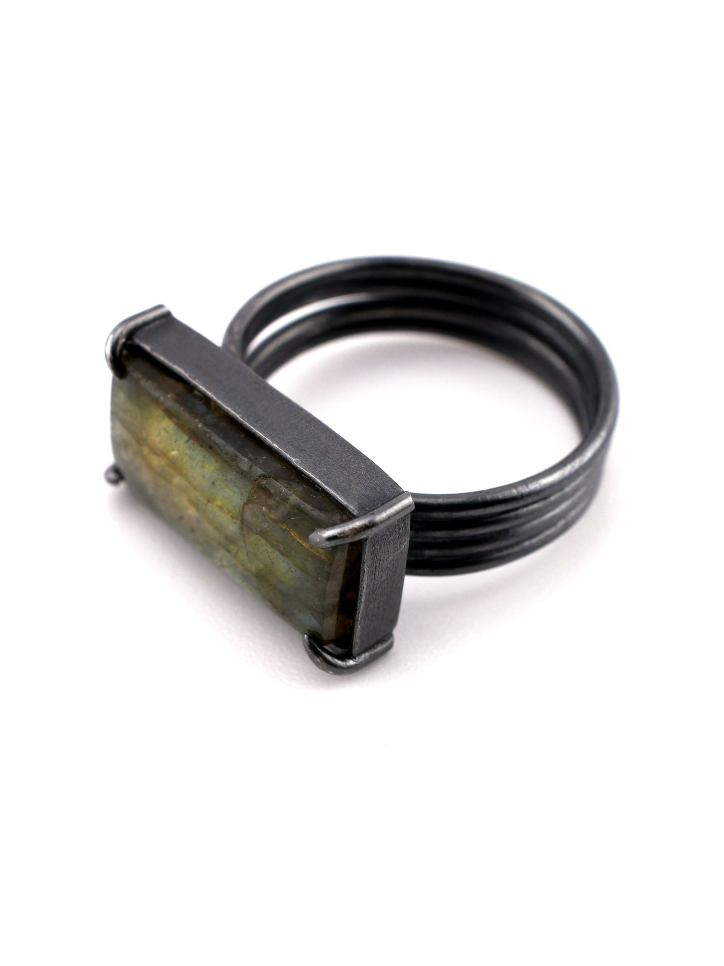 Ring with a rectangular stone and black band on a white background