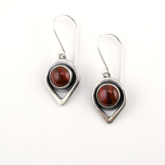 Pair of earrings with teardrop-shaped silver frames and brown gemstones on a white background
