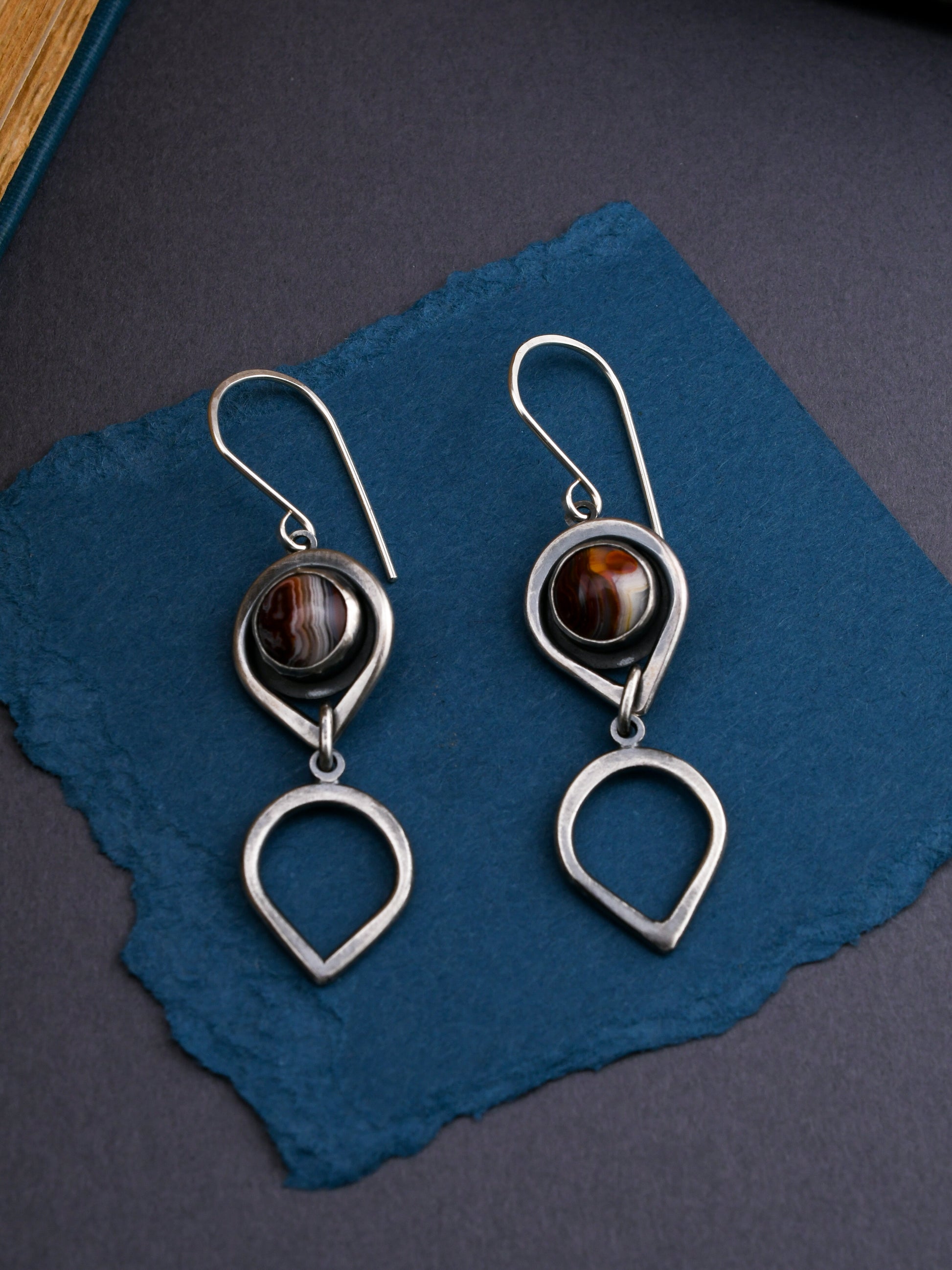 Silver earrings with red stones on a blue fabric background