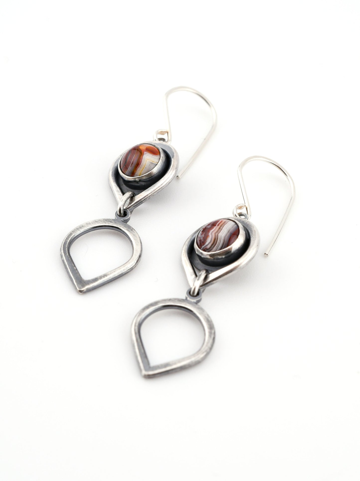 Silver earrings with teardrop designs on a white background