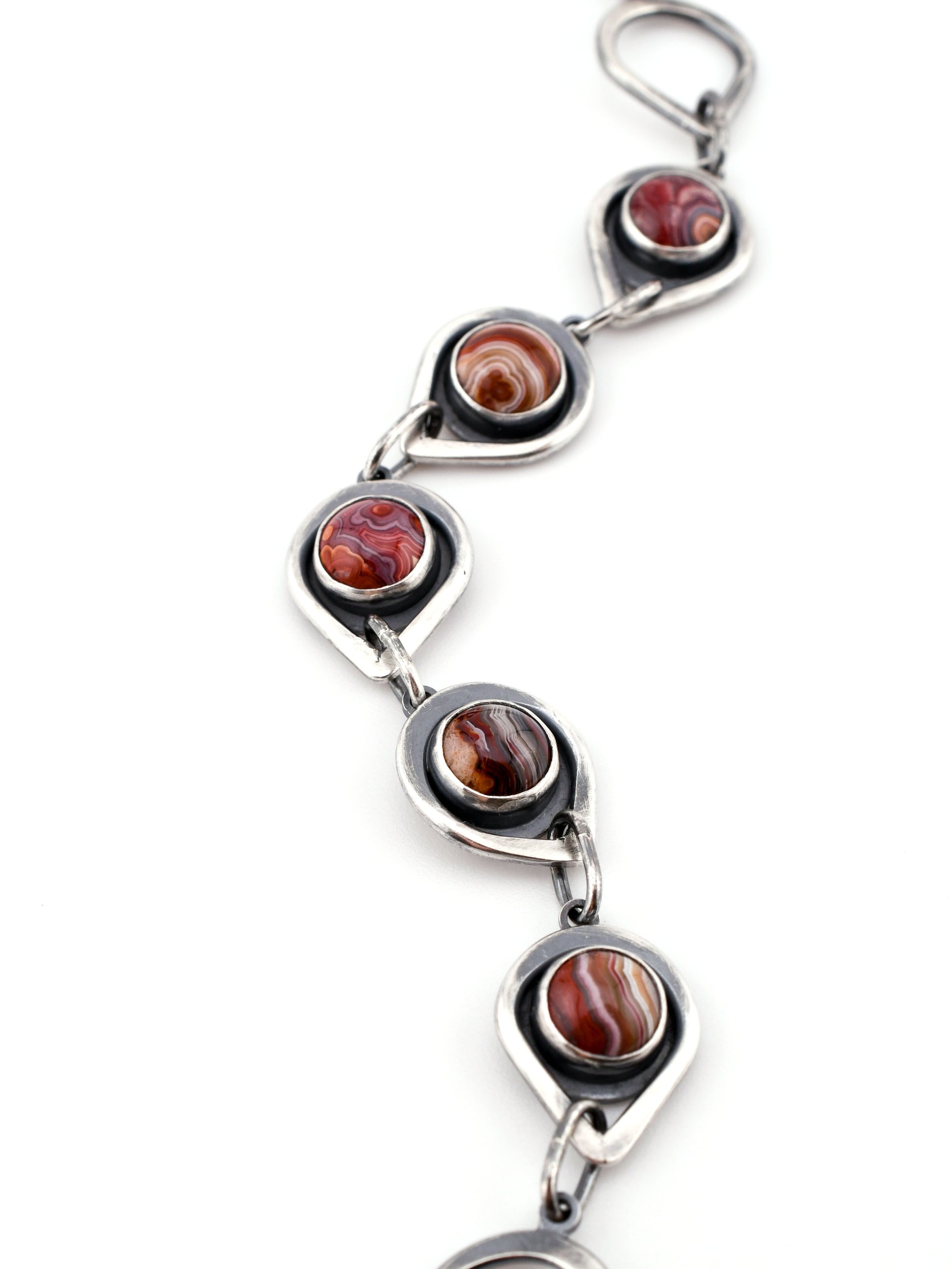 Silver bracelet with red gemstones on a white background