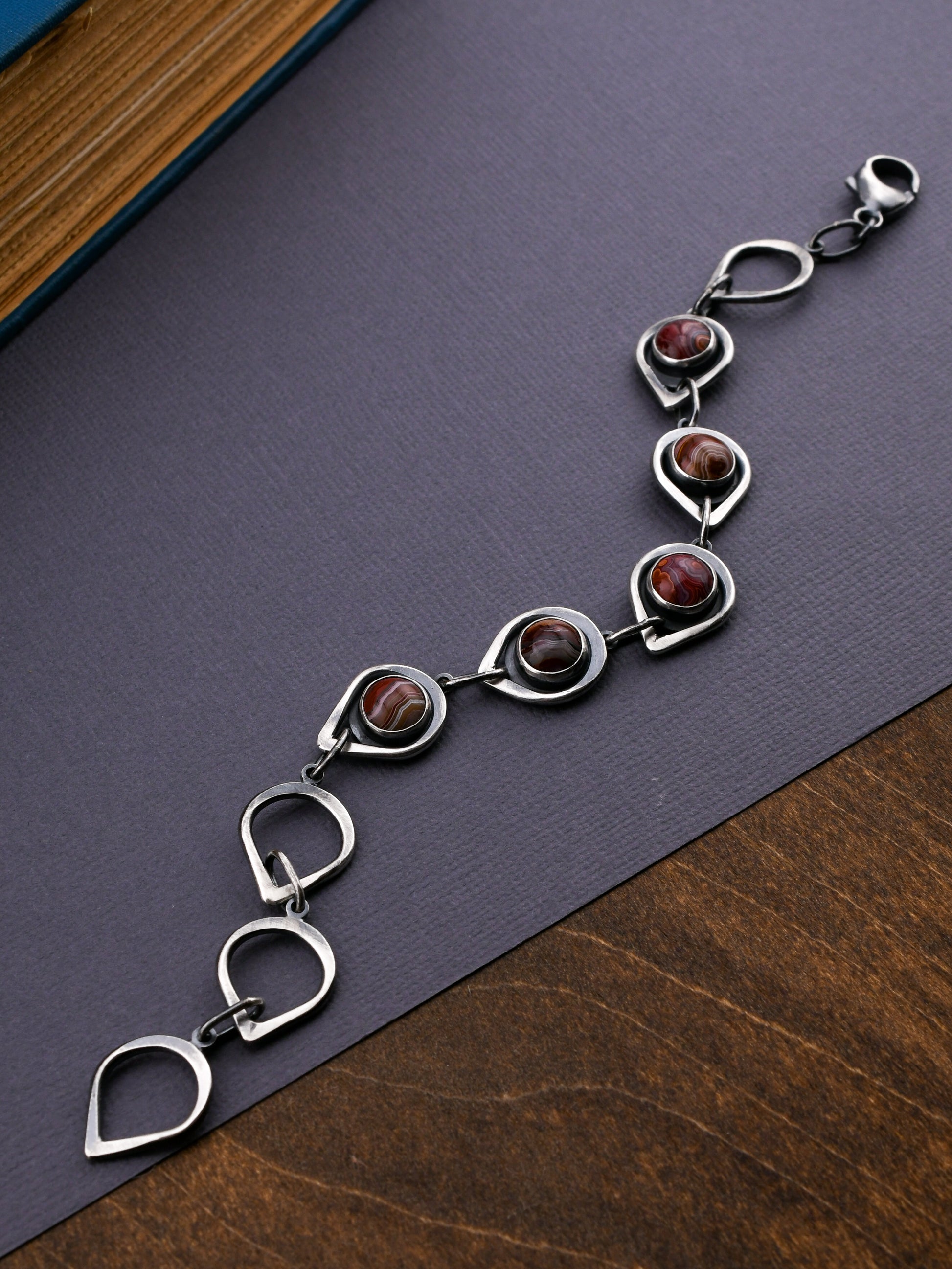 Silver bracelet with red stones on a dark surface