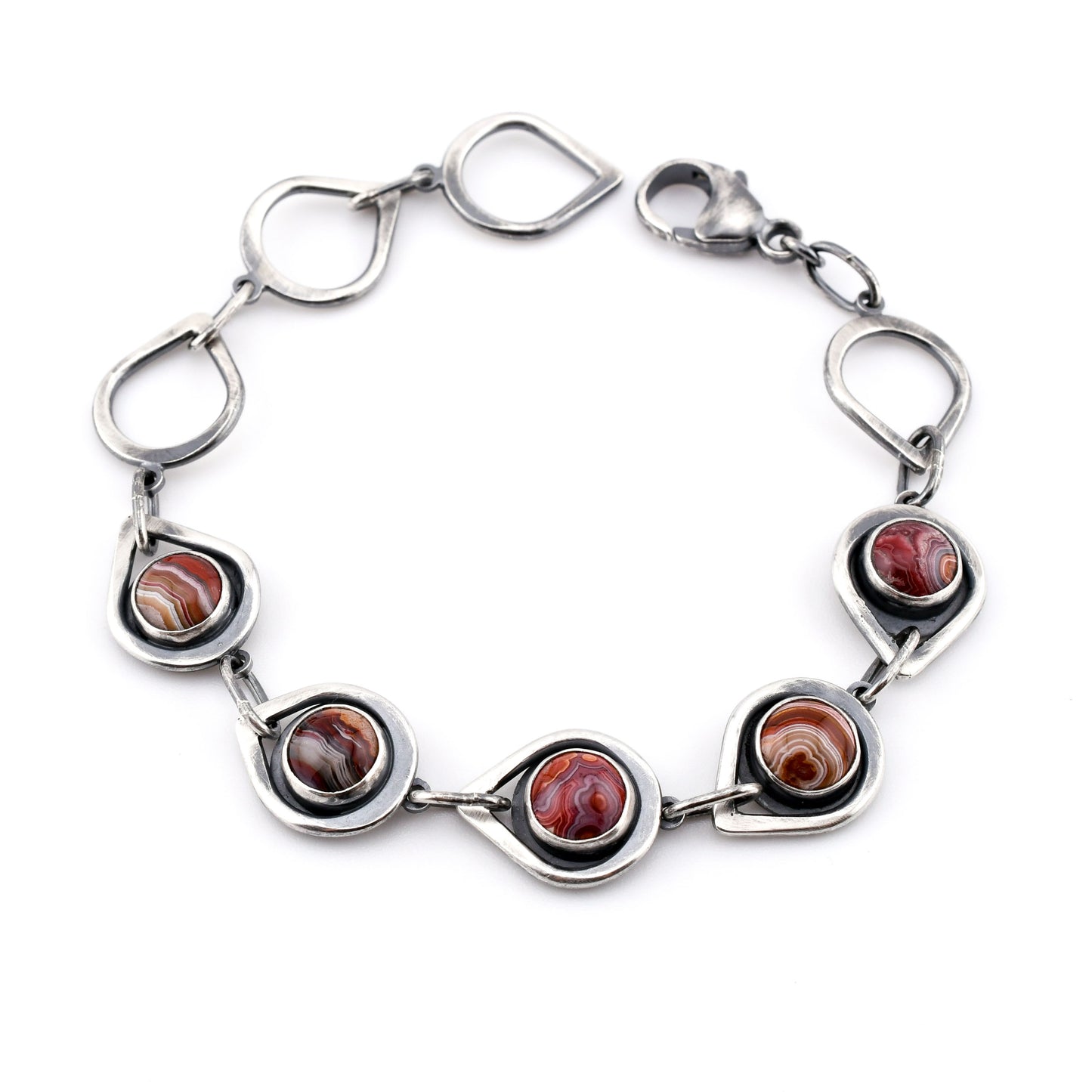 Silver bracelet with circular red stones on a white background