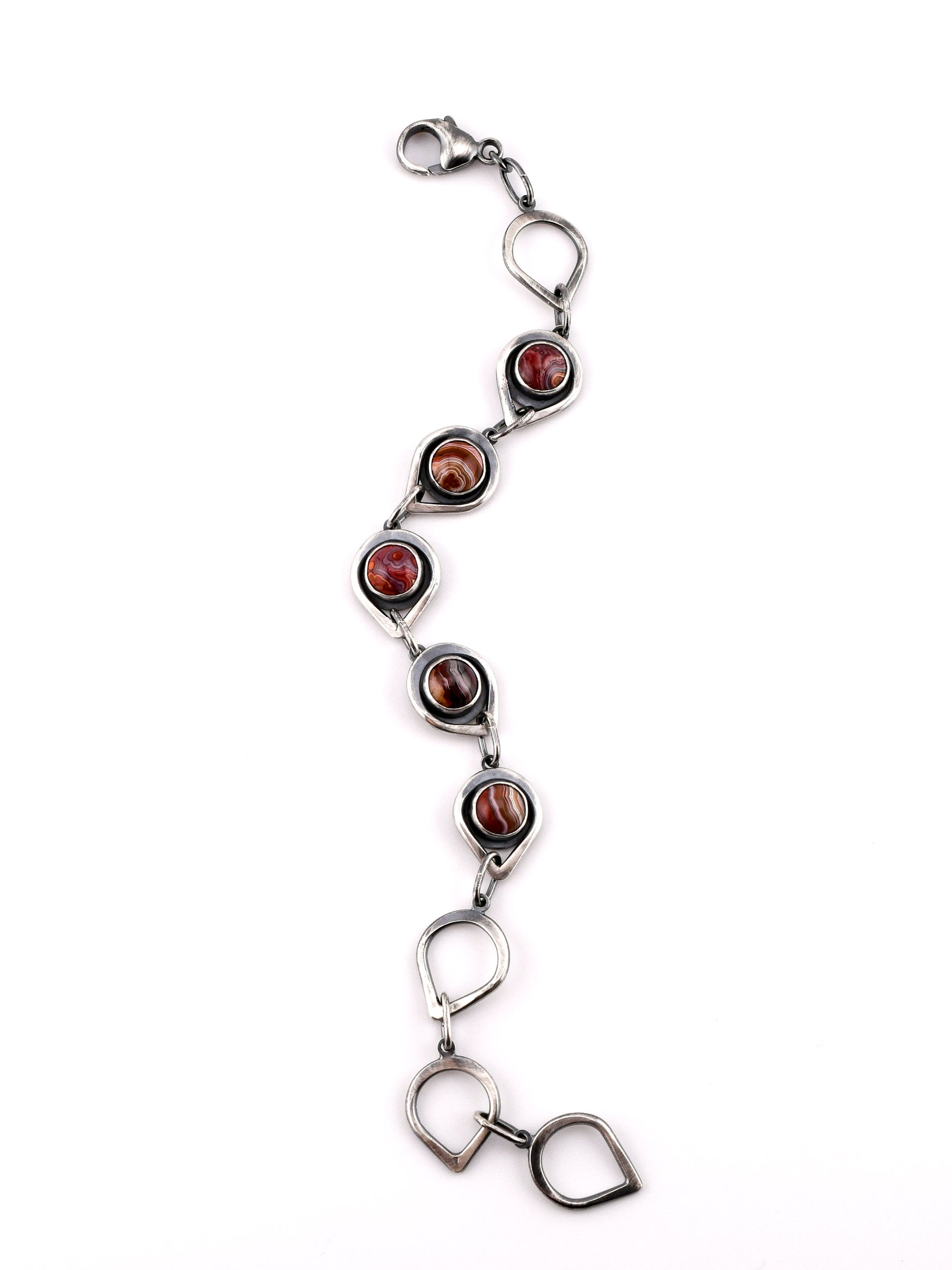 Silver bracelet with red stones on a white background