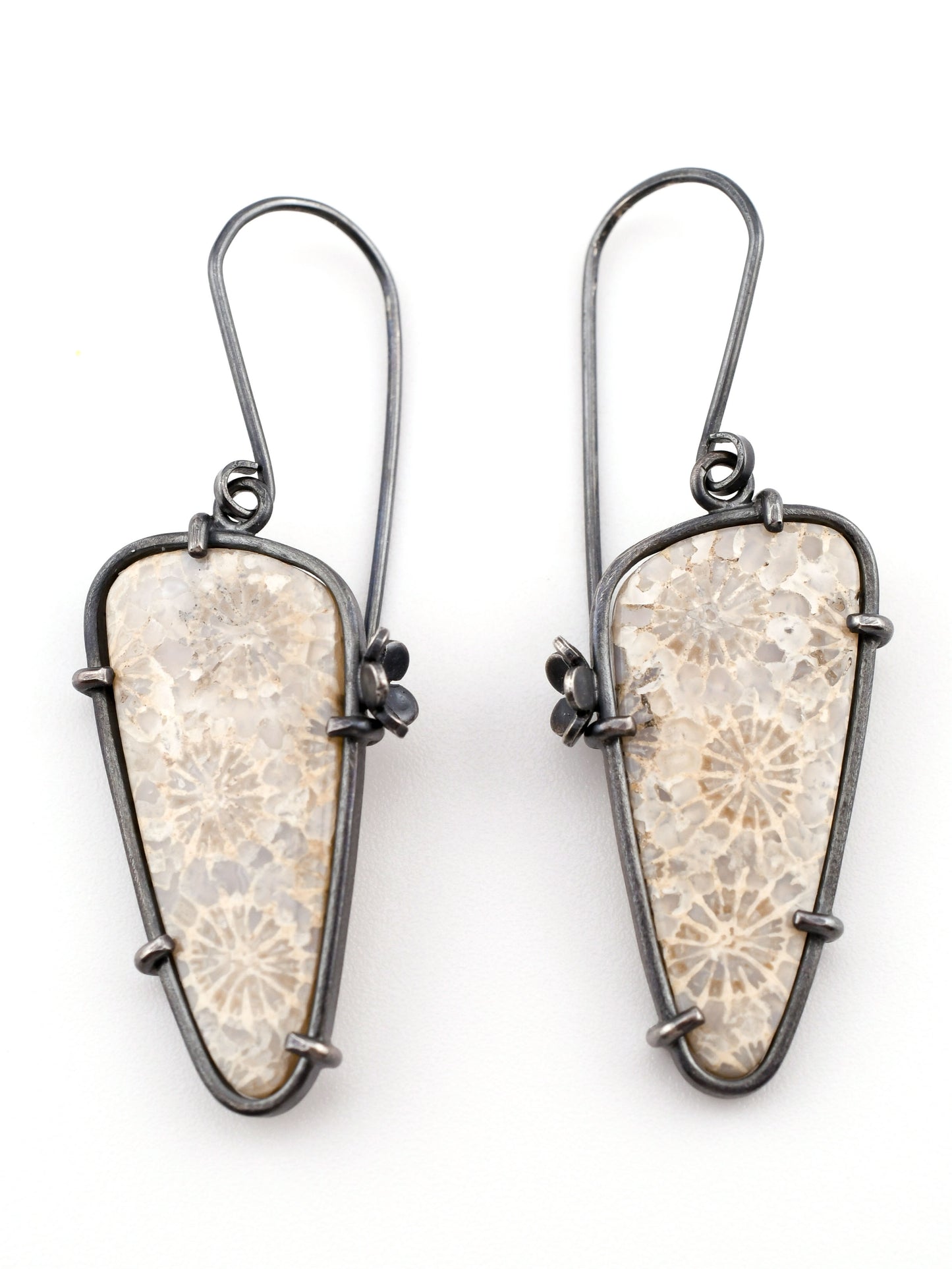 Pair of earrings with textured stone-like design on a white background